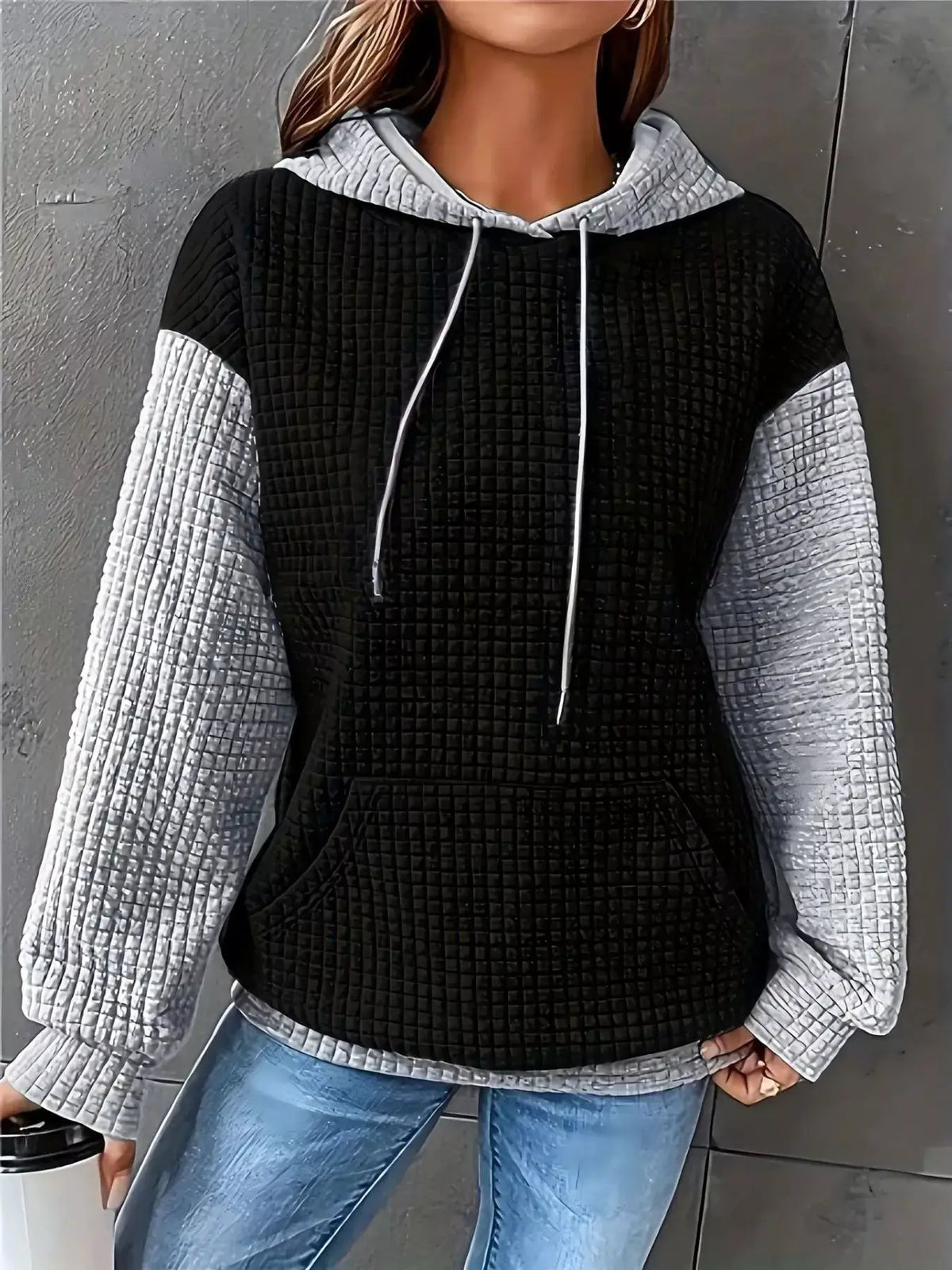 Plus-size textured kangaroo-pocket hoodie by Trendsi in black with gray quilted sleeves.