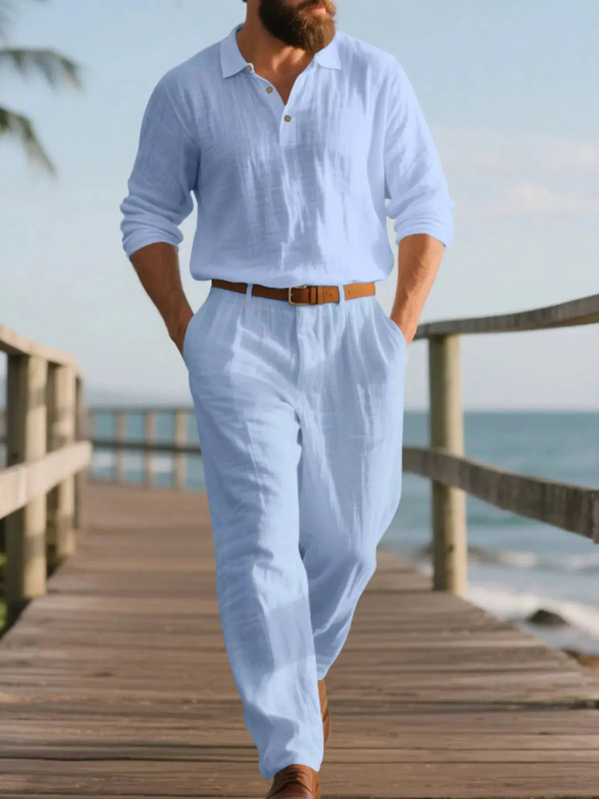 Mens plus-size long-sleeve linen top and pants set in light blue, with brown belt on a seaside boardwalk.