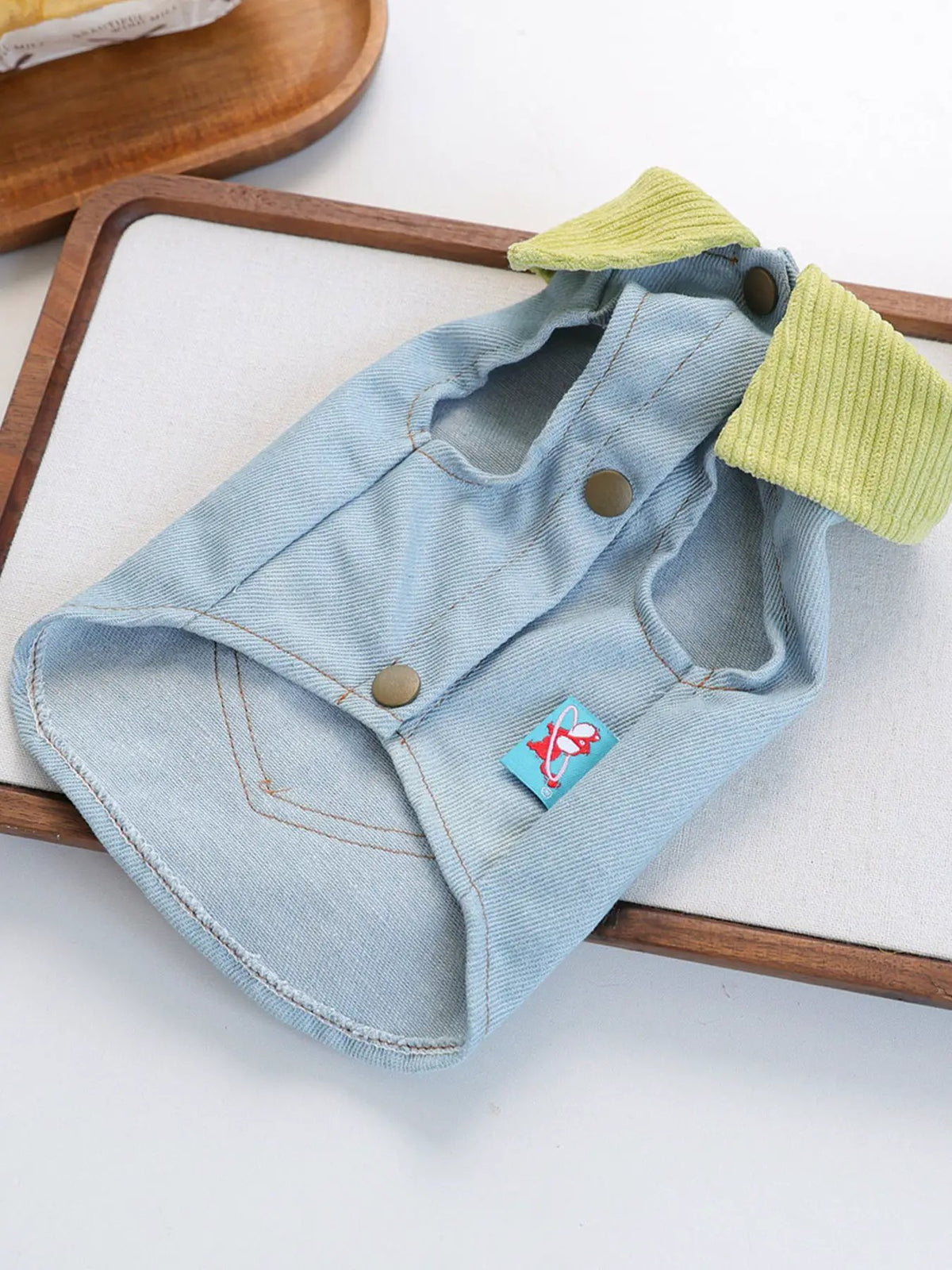 Denim pet top in light blue with lime ribbed collar and metal snaps