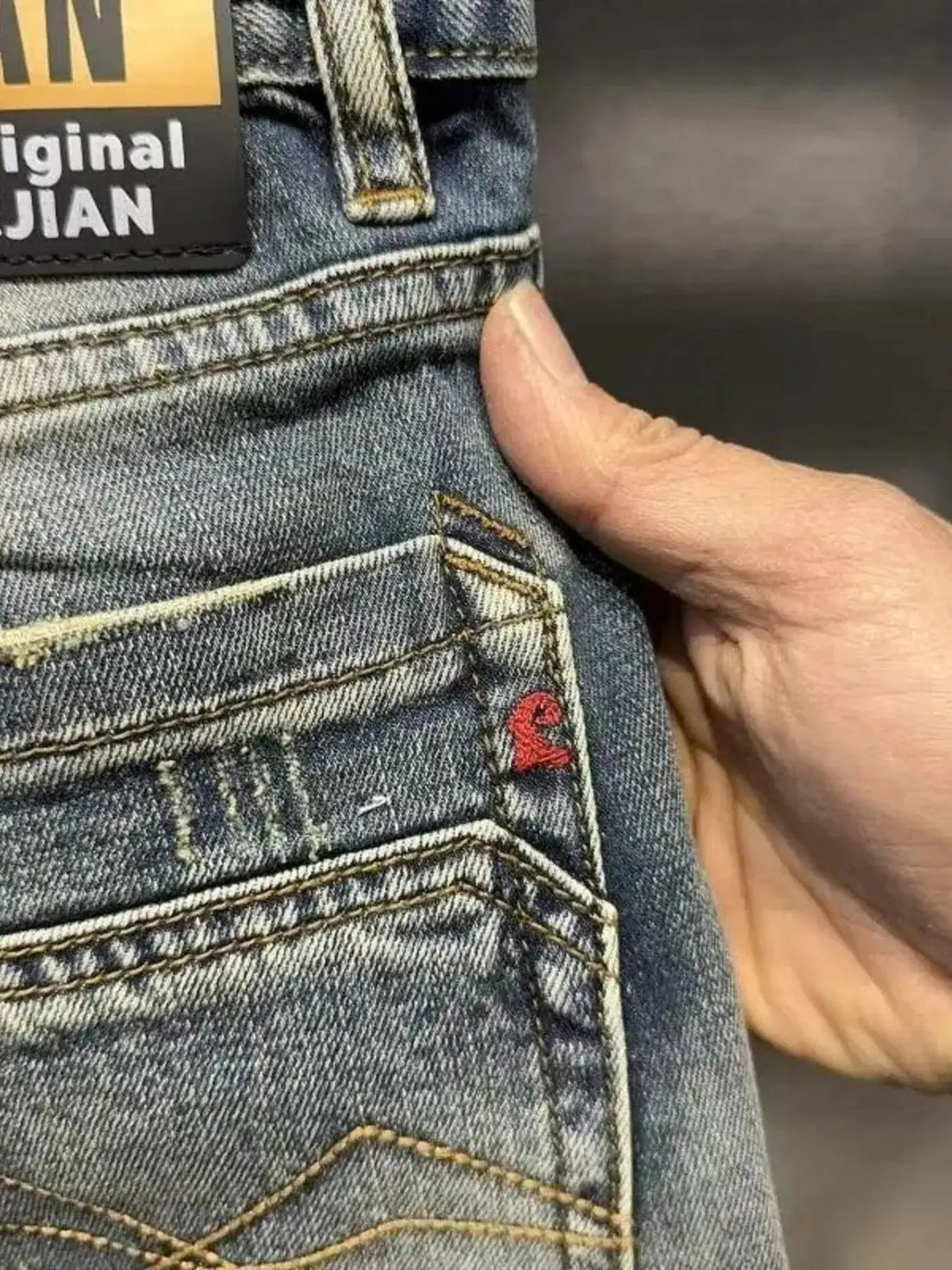 Men's washed denim stretch shorts; blue fabric with back pocket stitching and red tag.