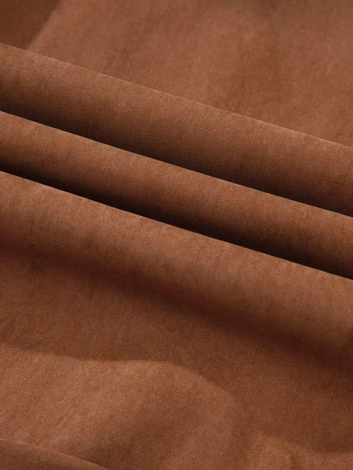 Dress fabric close-up in warm brown with soft folds and smooth texture