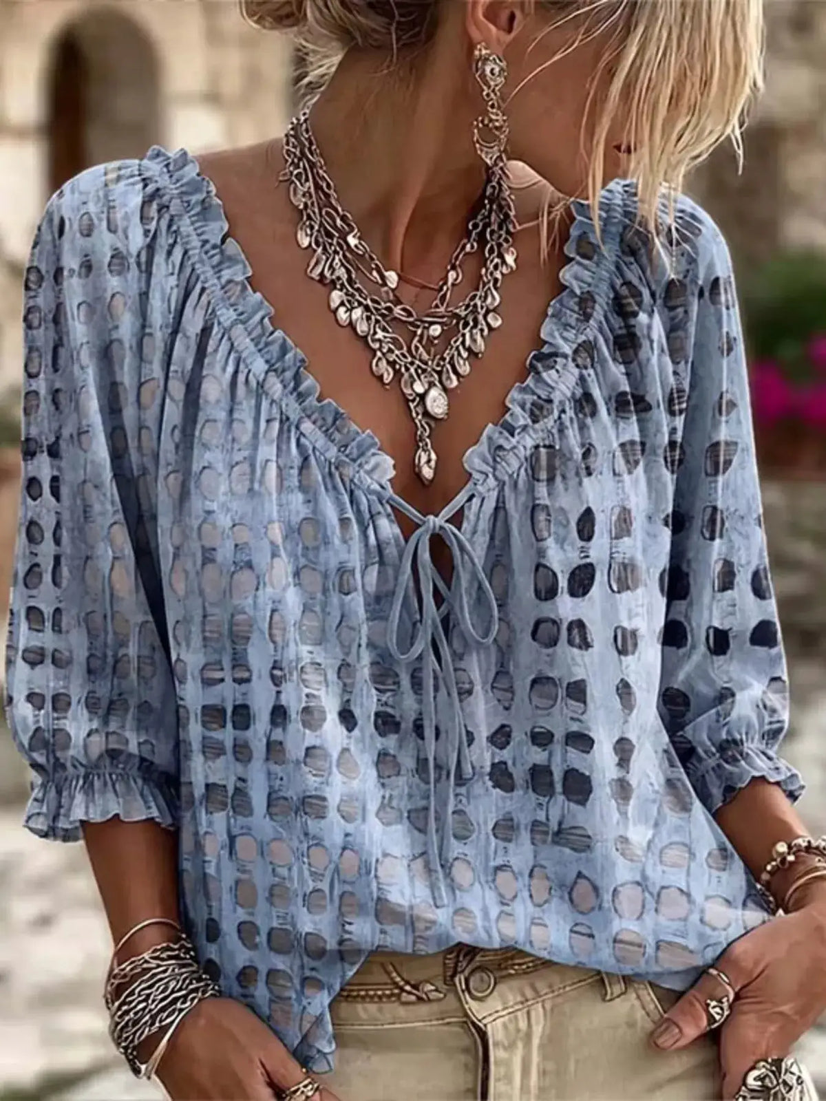 Plus-size blue tie-neck blouse with 3/4 sleeves and ruffle trim, sheer dotted pattern