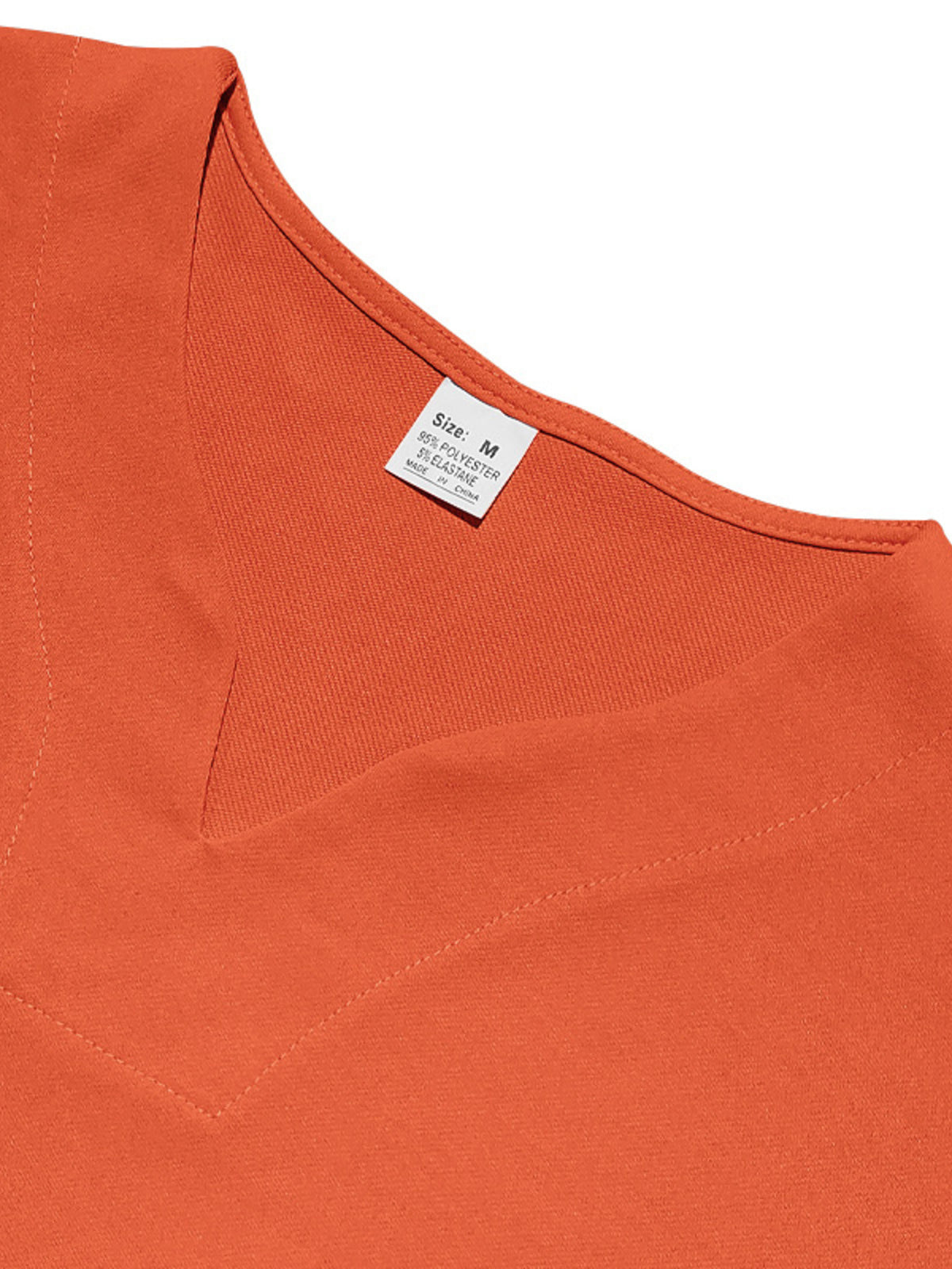 Men's orange T-shirt neckline close-up with size M tag and visible stitching