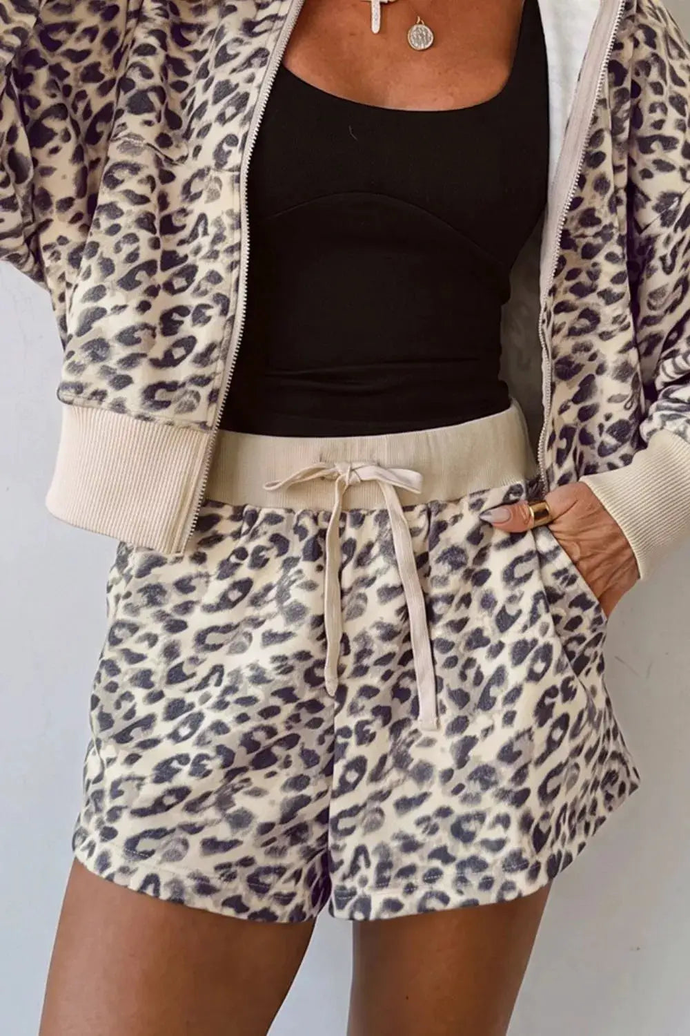 Two-piece leopard print zip-up hoodie and shorts set by Trendsi, beige with black spots.