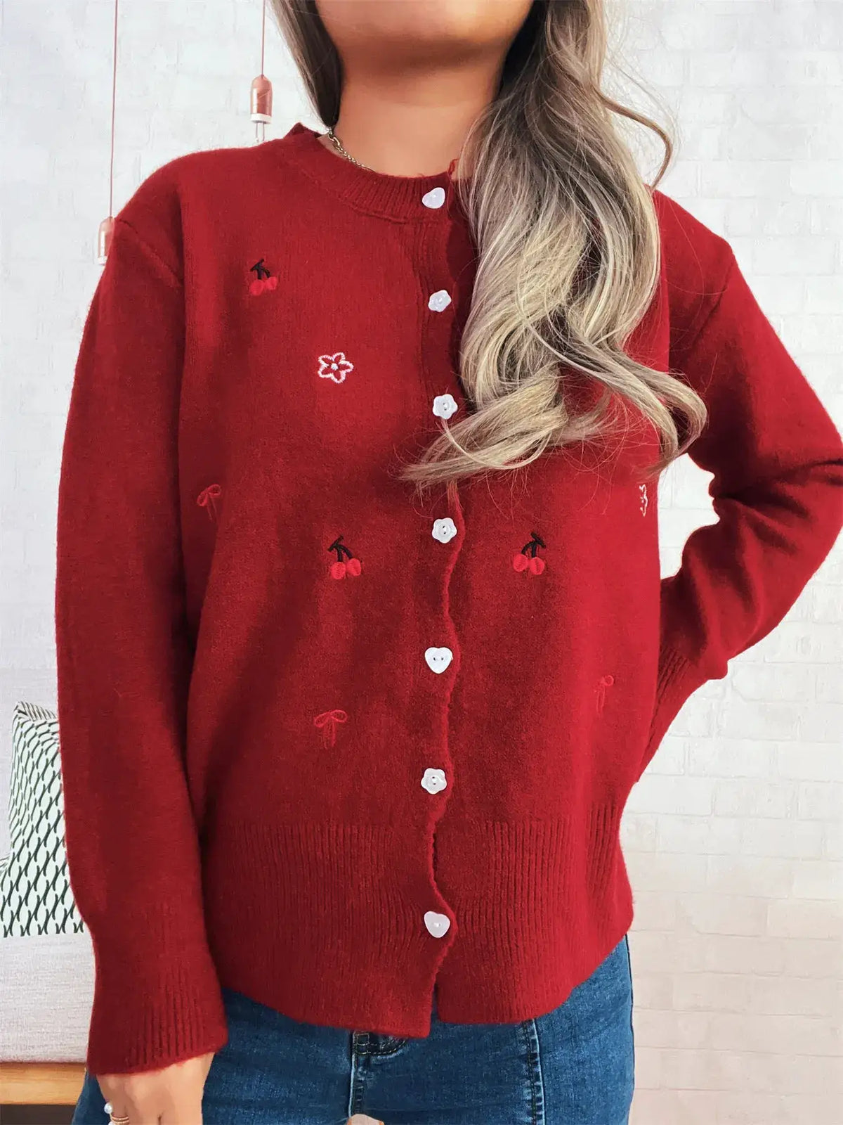 Ribbed button-front knit cardigan in red with cherry embroidery and white buttons.