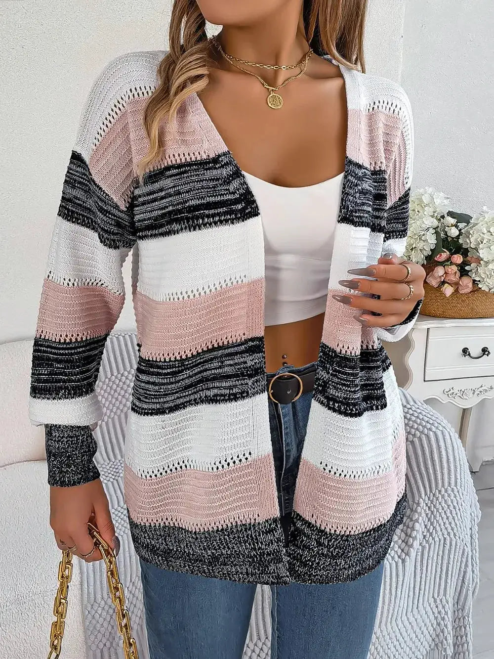Openwork striped open-front cardigan in white, pink, and black with a relaxed knit.