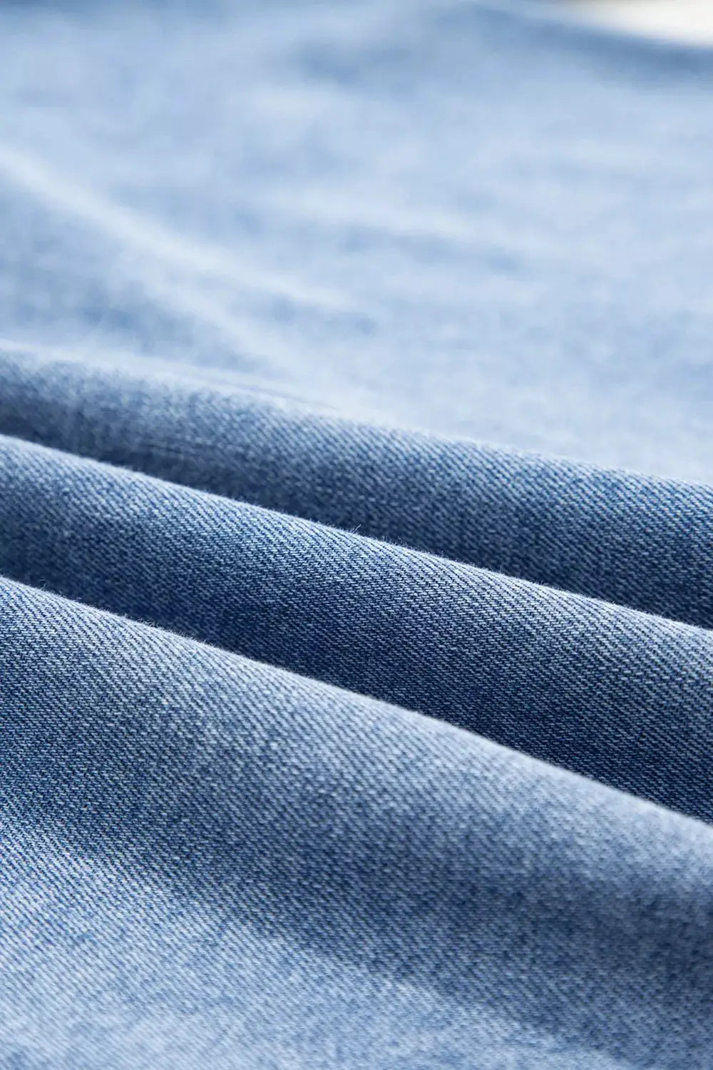 Denim shirt blue cotton-blend fabric close-up texture and folds
