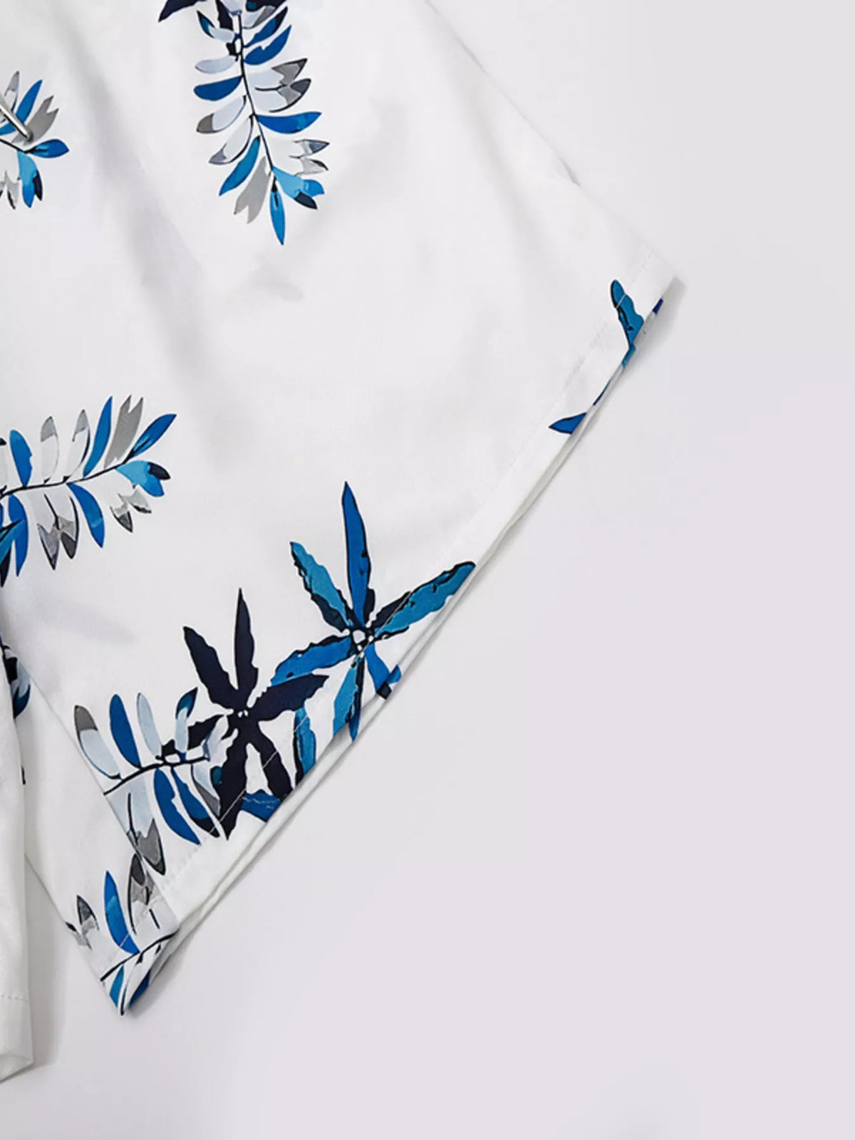 Men's full-size tropical print short-sleeve shirt and shorts set on white fabric with blue and gray palm leaf pattern.