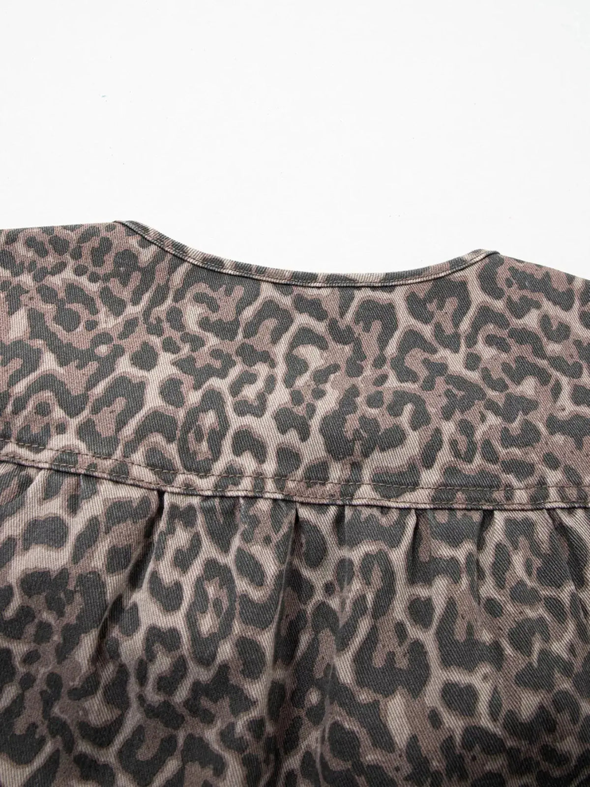 Women's leopard print denim top, gray fabric with tan leopard spots.