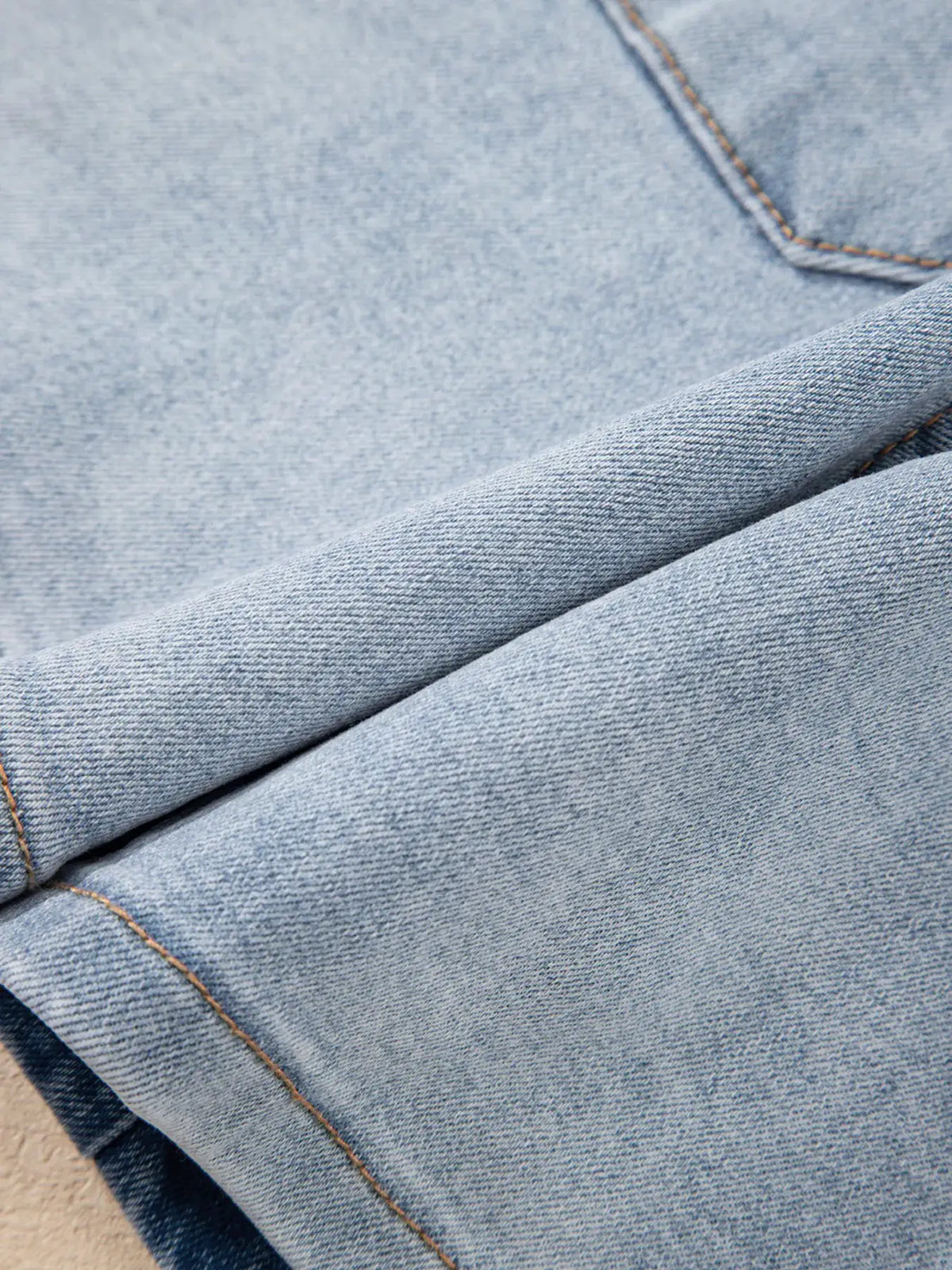 Wash High Rise Denim Shorts close-up of light blue denim fabric with orange stitching