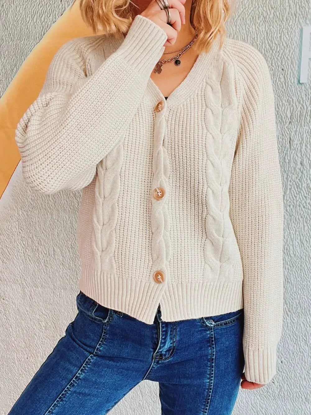 Soft cable-knit cardigan with V-neck and front buttons, long sleeves in cream