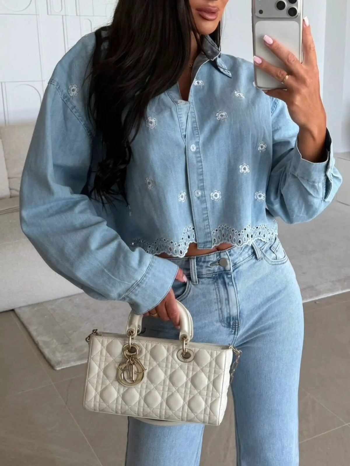 Embroidered cropped denim shirt in light blue with small white floral embroidery and scalloped hem.