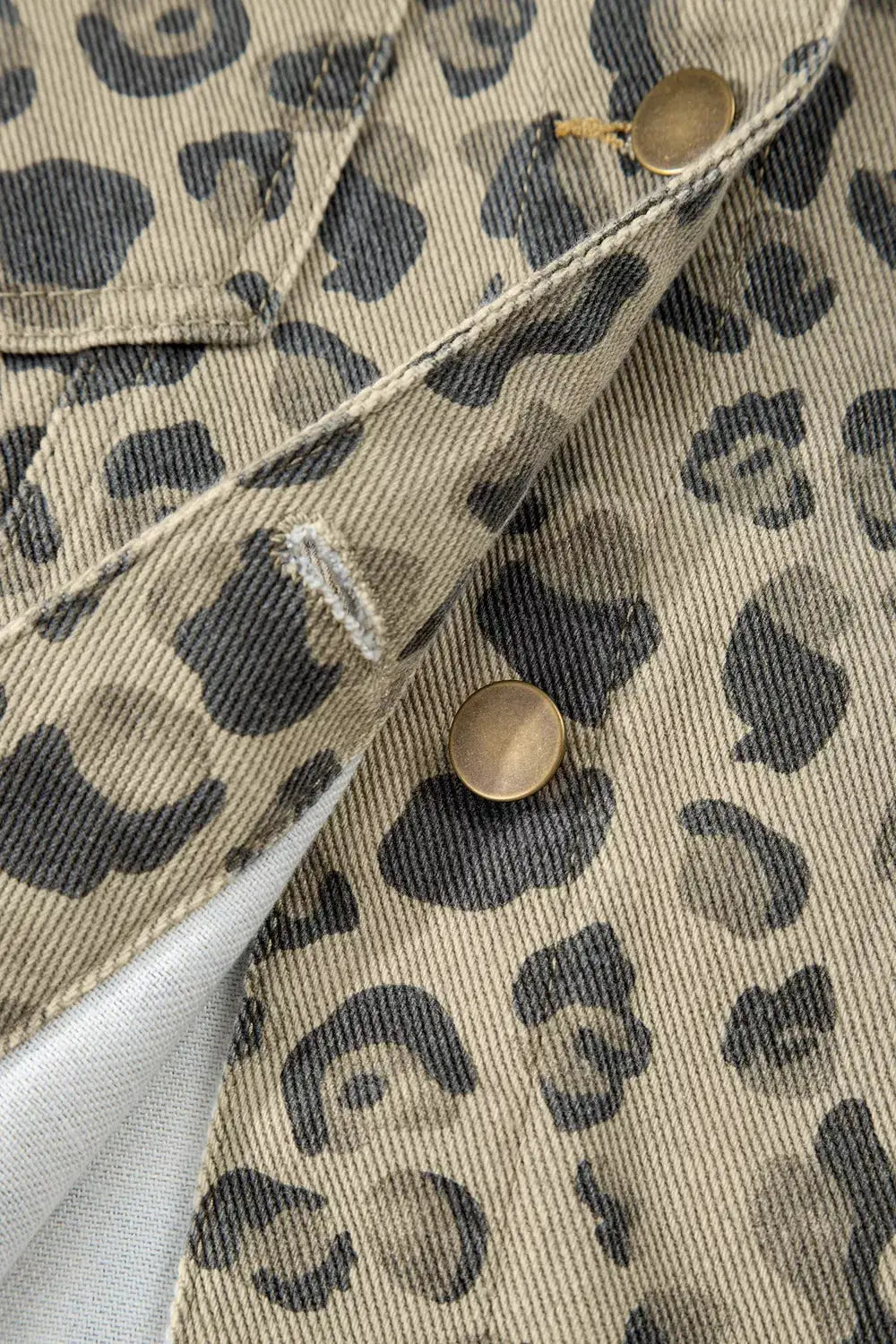 Leopard print denim jacket, button-down, cotton blend in beige with black spots, brass snap buttons.