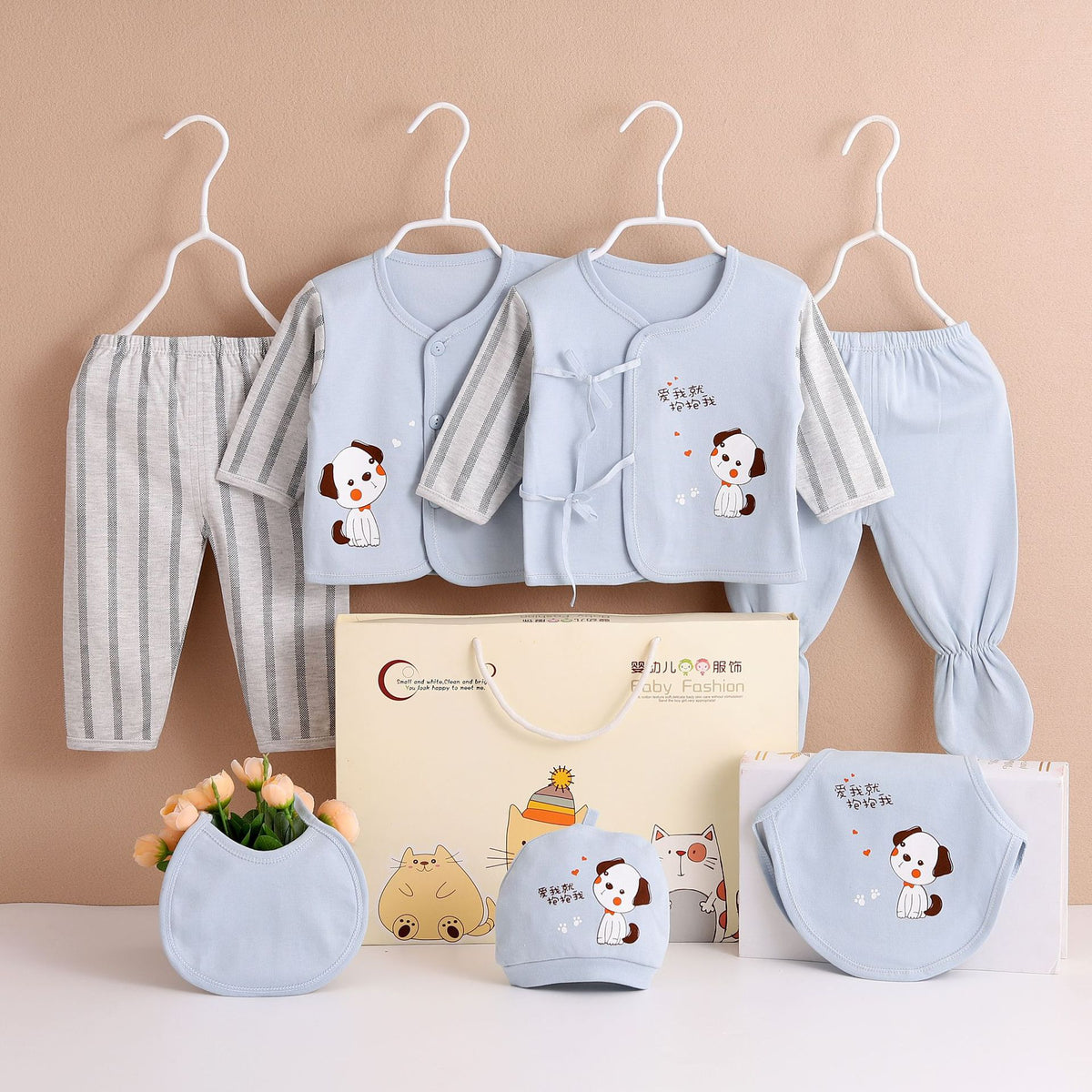 Seven piece newborn clothing set in light blue, featuring panda illustrations; shown on white hangers.
