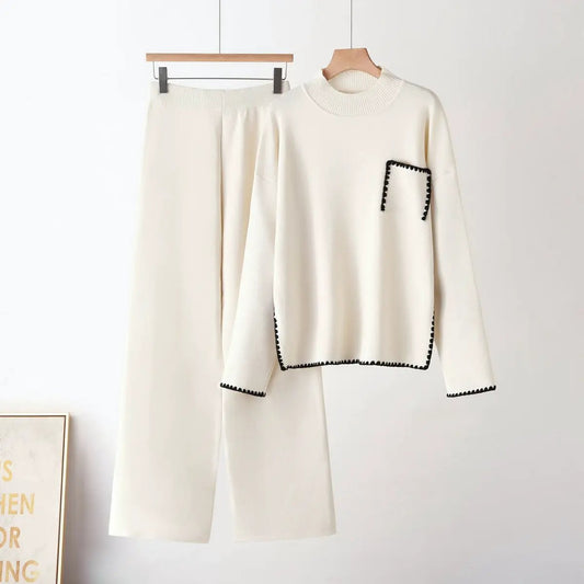 Two-piece knit set in cream with half-high neck top and straight-leg pants, black whipstitch trim on pocket and hems