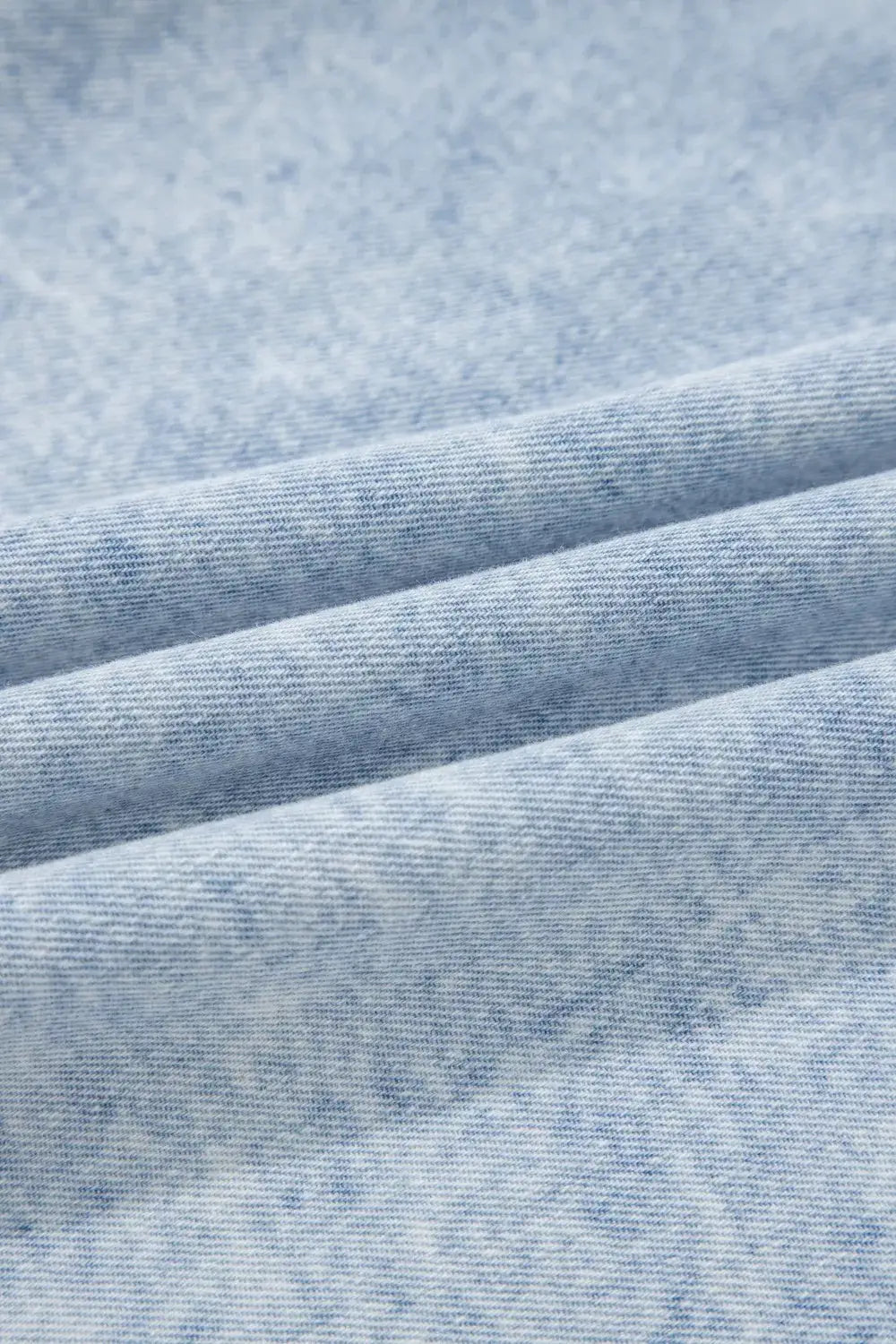 Vintage washed denim fabric close-up in light blue
