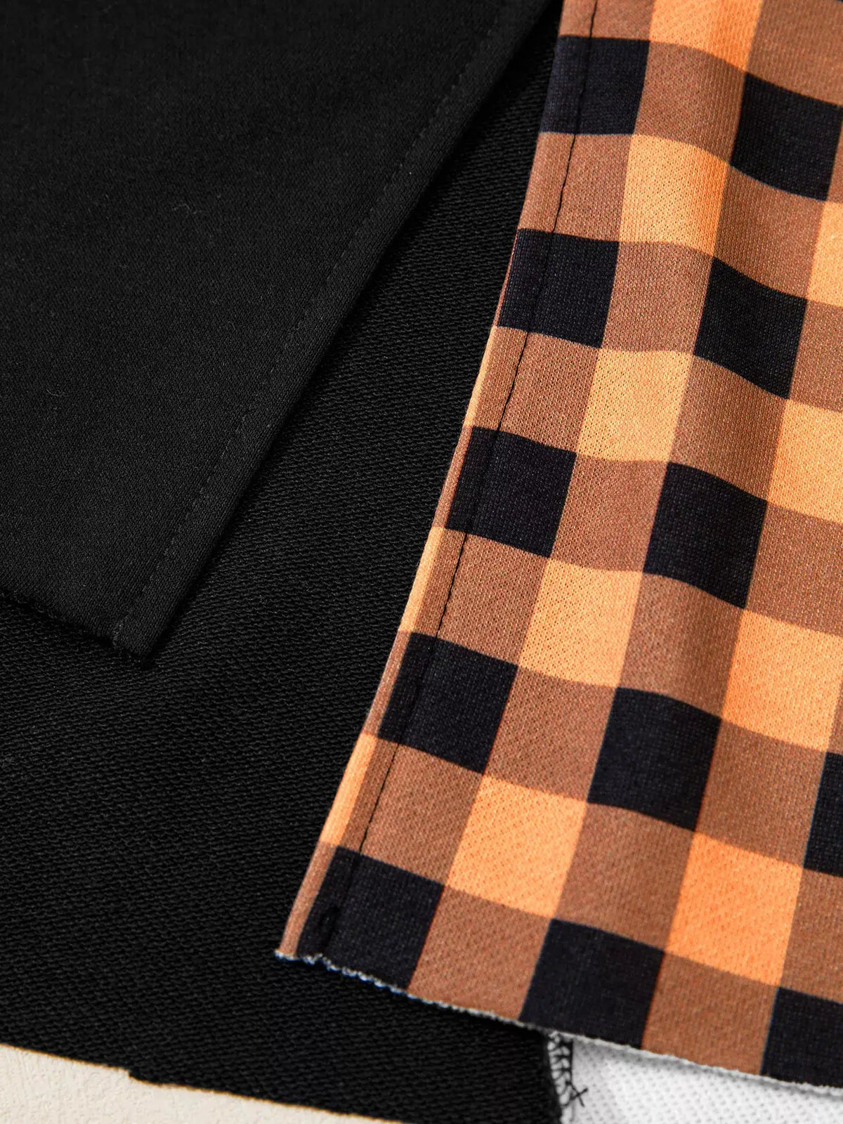 Patchwork Plaid Pumpkin Face Long Sleeve Top with black body and orange plaid sleeves