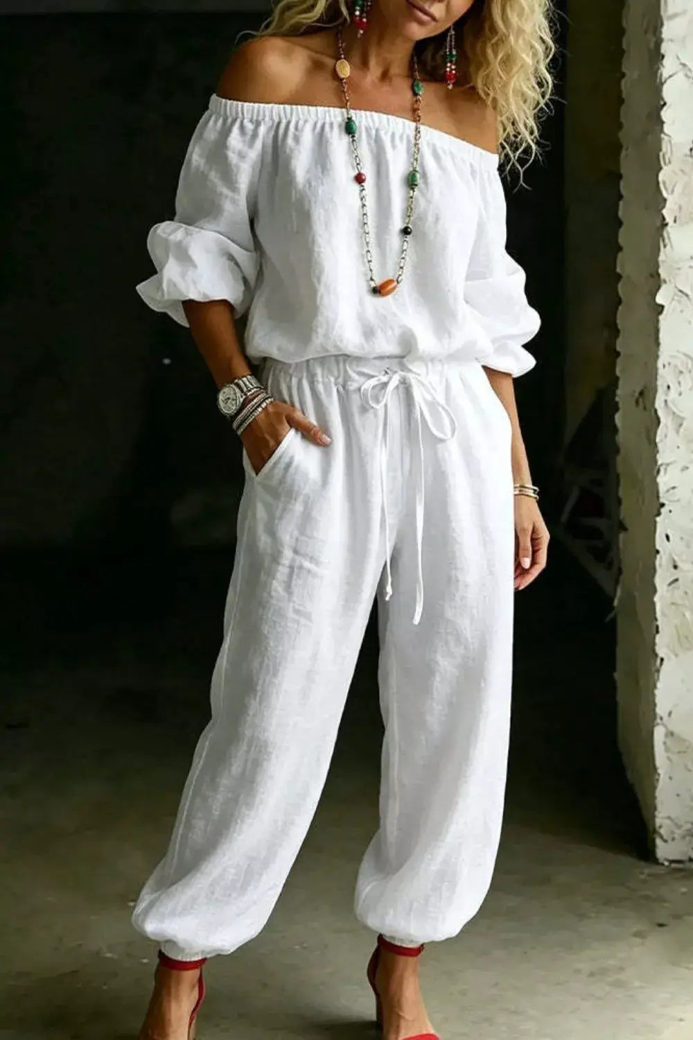 Plus-size two-piece white linen off-shoulder top and pants set with elastic neckline, puff sleeves, and drawstring waist