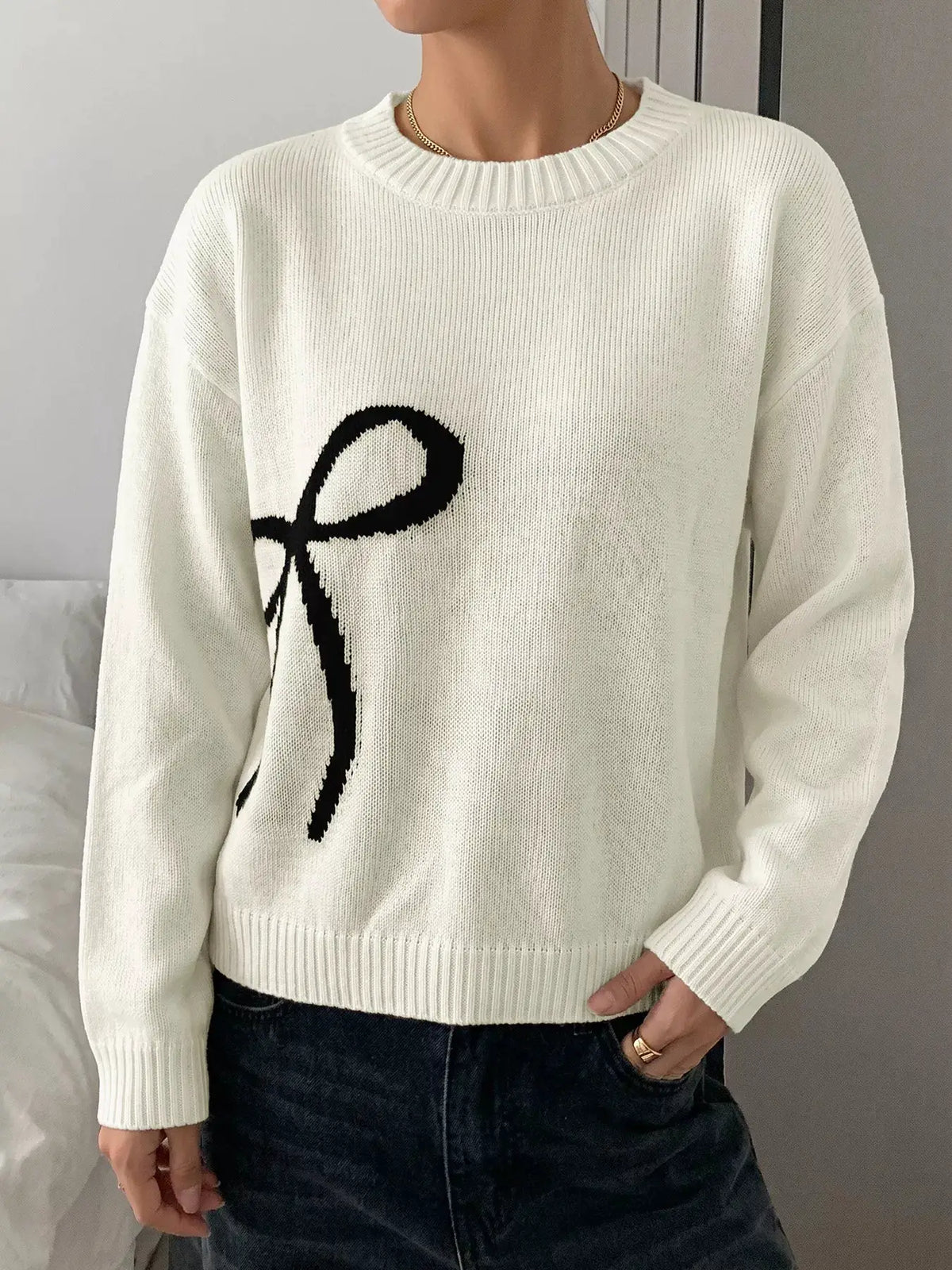 Bow graphic acrylic sweater in white with round neckline and soft stretch fit