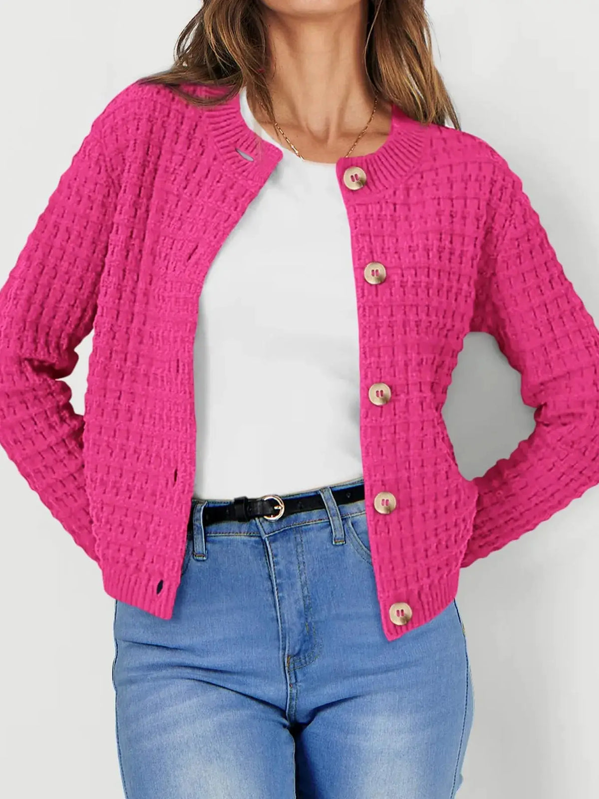 Textured stretchy knit button-front cardigan by Trendsi in hot pink with beige buttons worn over a white top