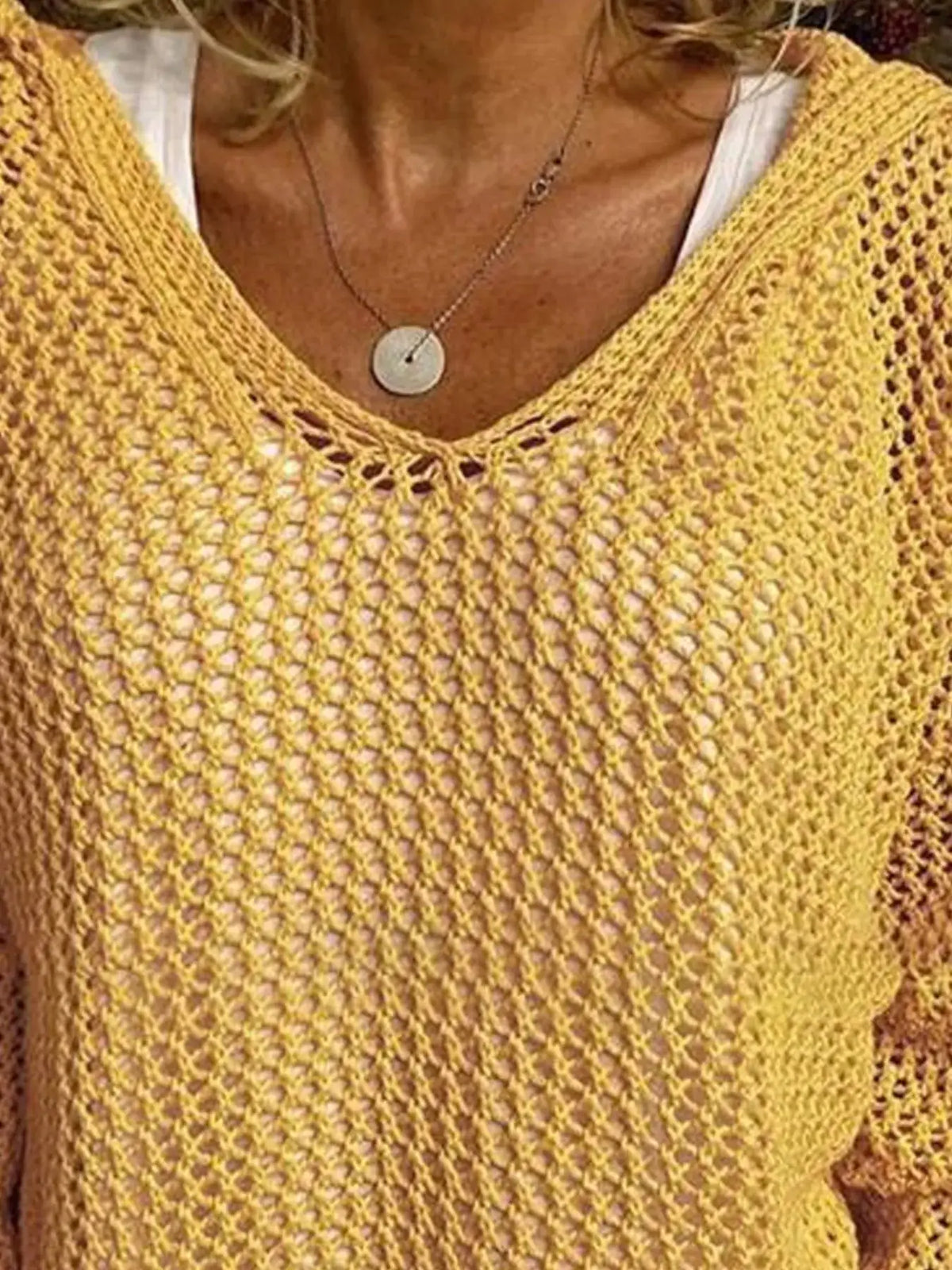 Openwork long-sleeve knit beach cover up in yellow with crochet-style mesh.
