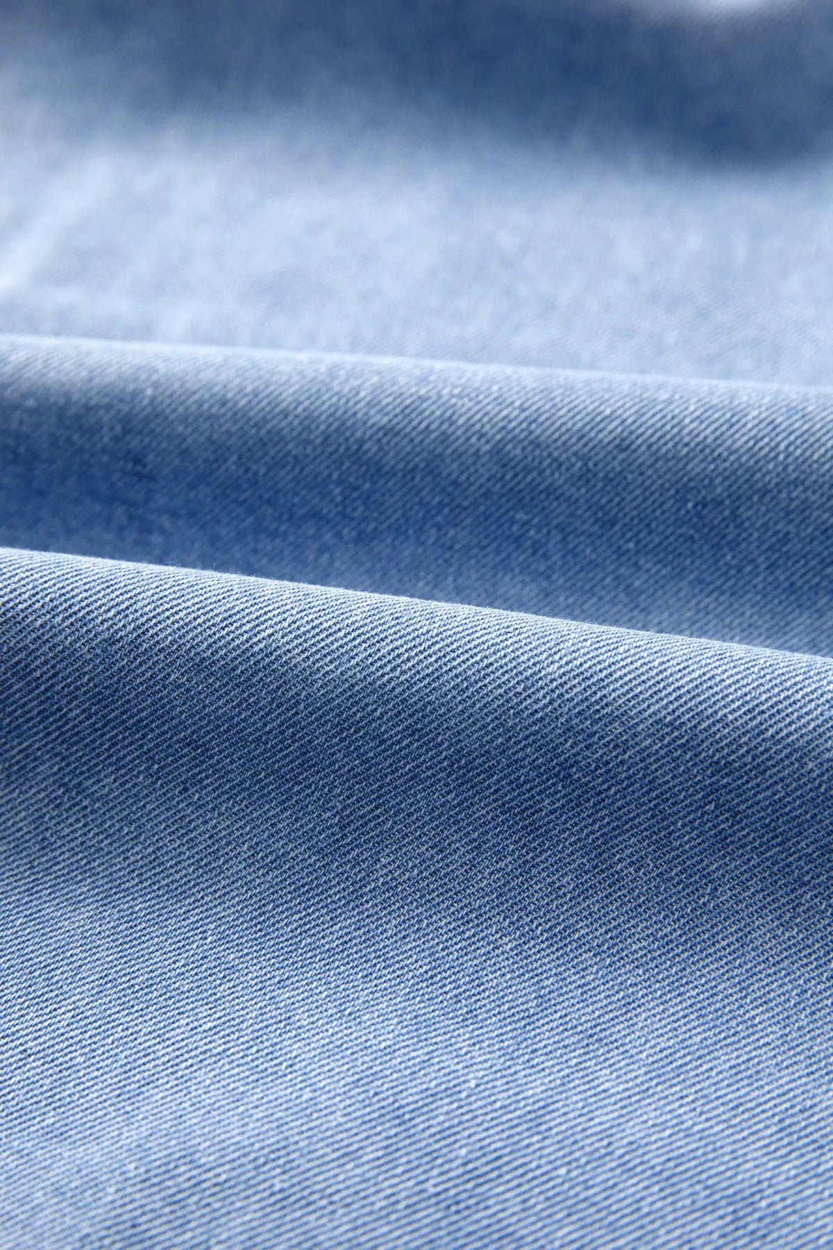 Distressed denim top fabric close-up in blue denim texture