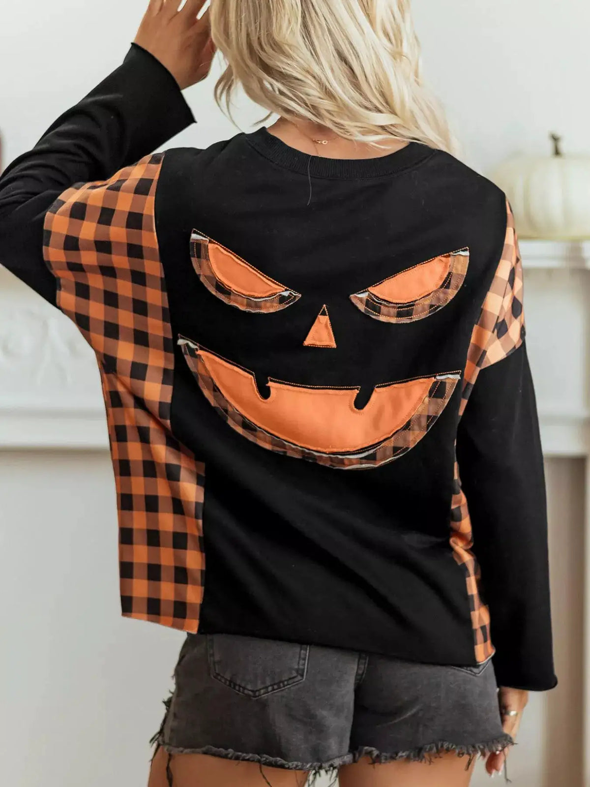 Patchwork Plaid Pumpkin Face Long Sleeve Top in black with orange plaid sleeves, by Trendsi.