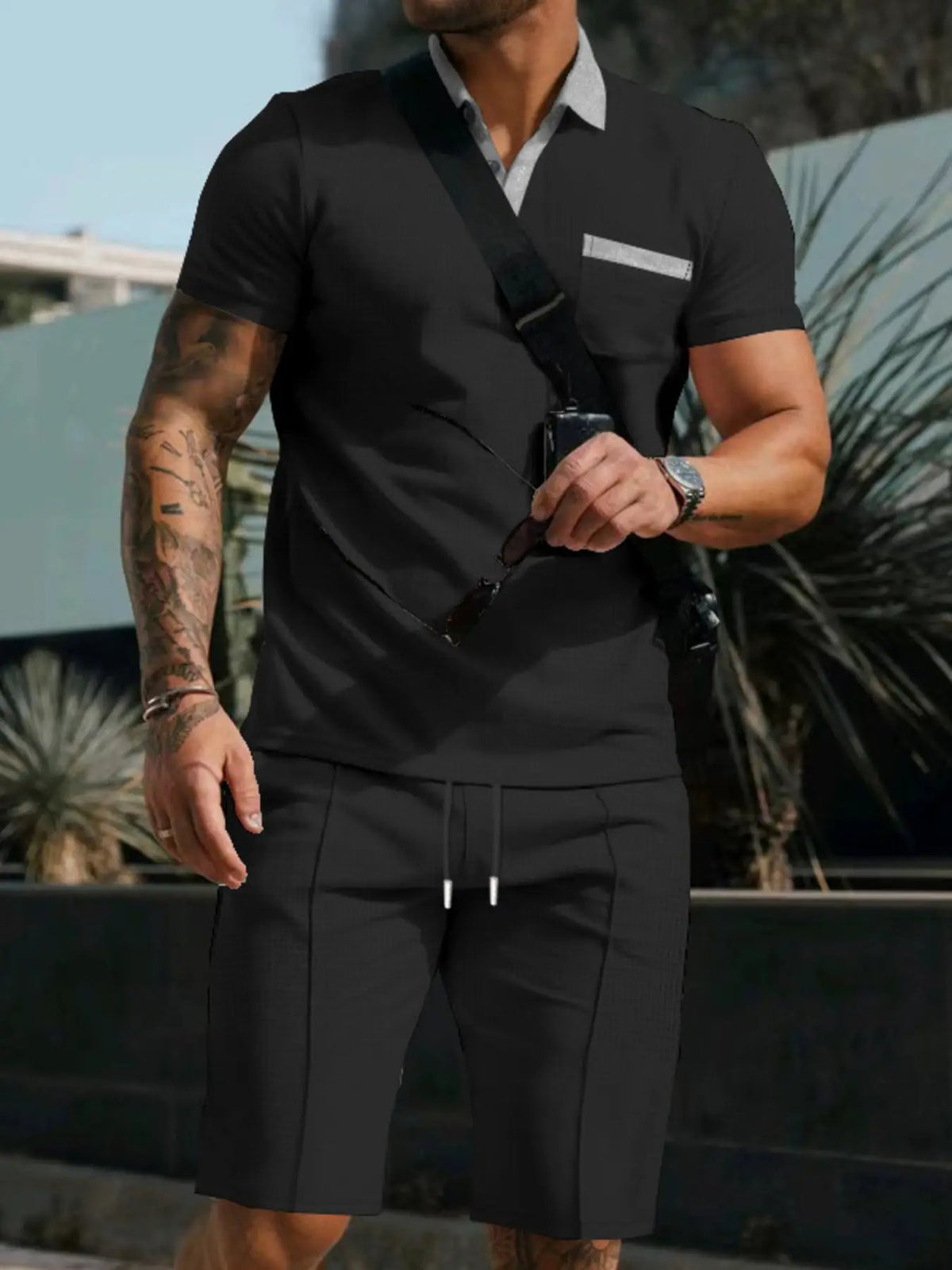 Mens black short-sleeve polo and shorts set with front pockets, stretch fit, two-piece ensemble