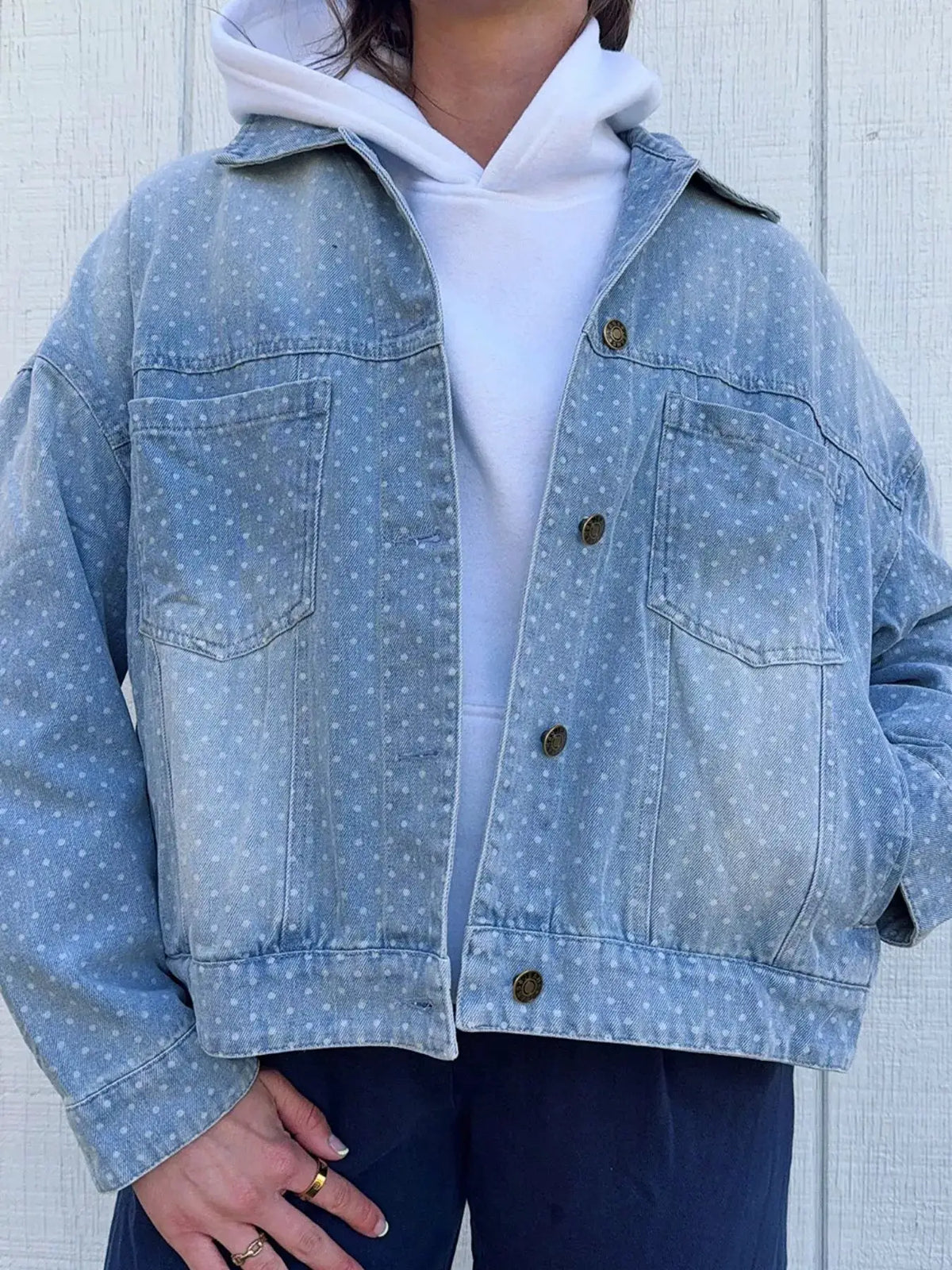 Polka dot long-sleeve denim jacket with pockets in light blue wash, worn over a white hoodie, by Trendsi