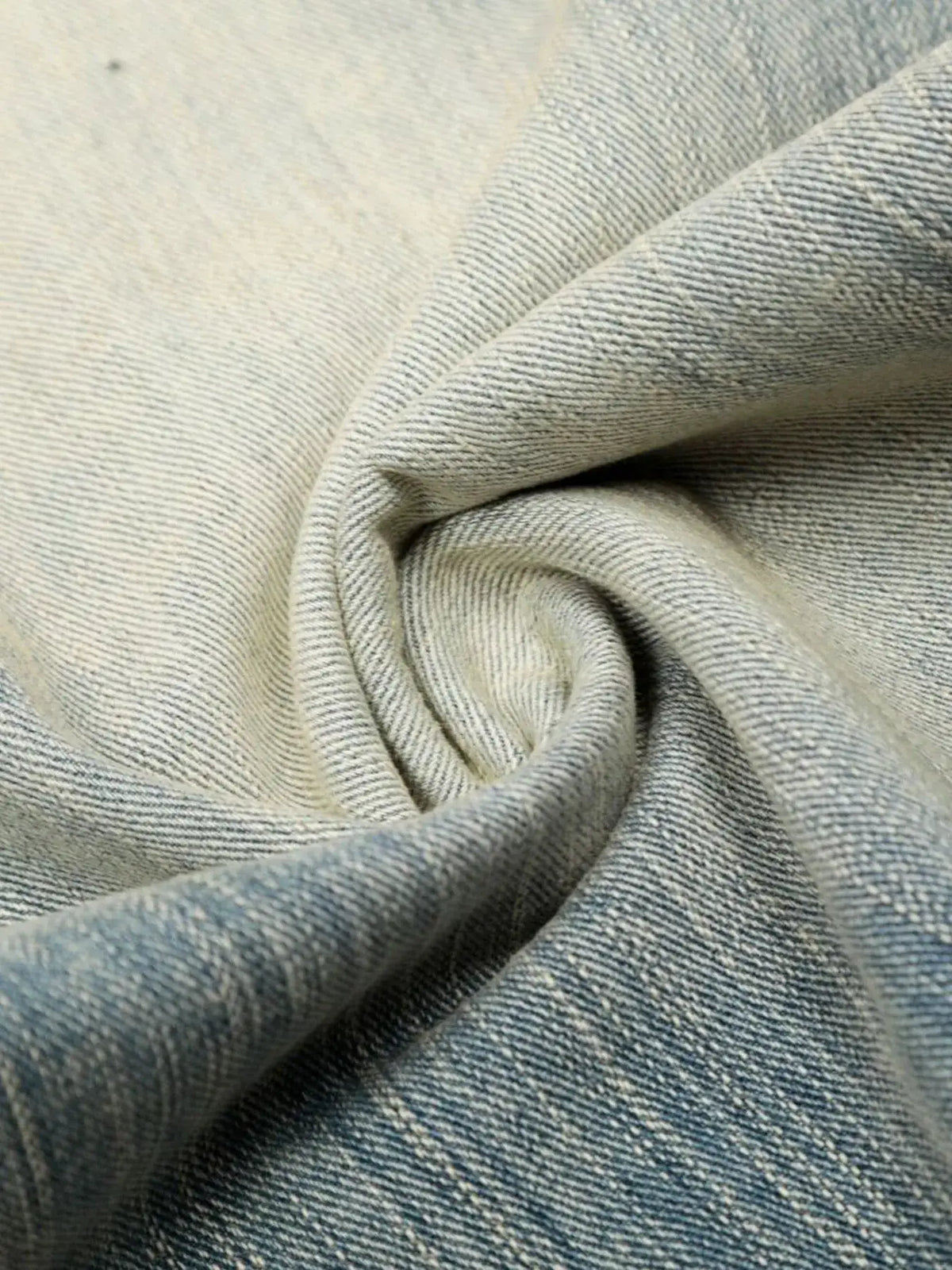 Mens washed denim shorts fabric close-up in light blue denim texture