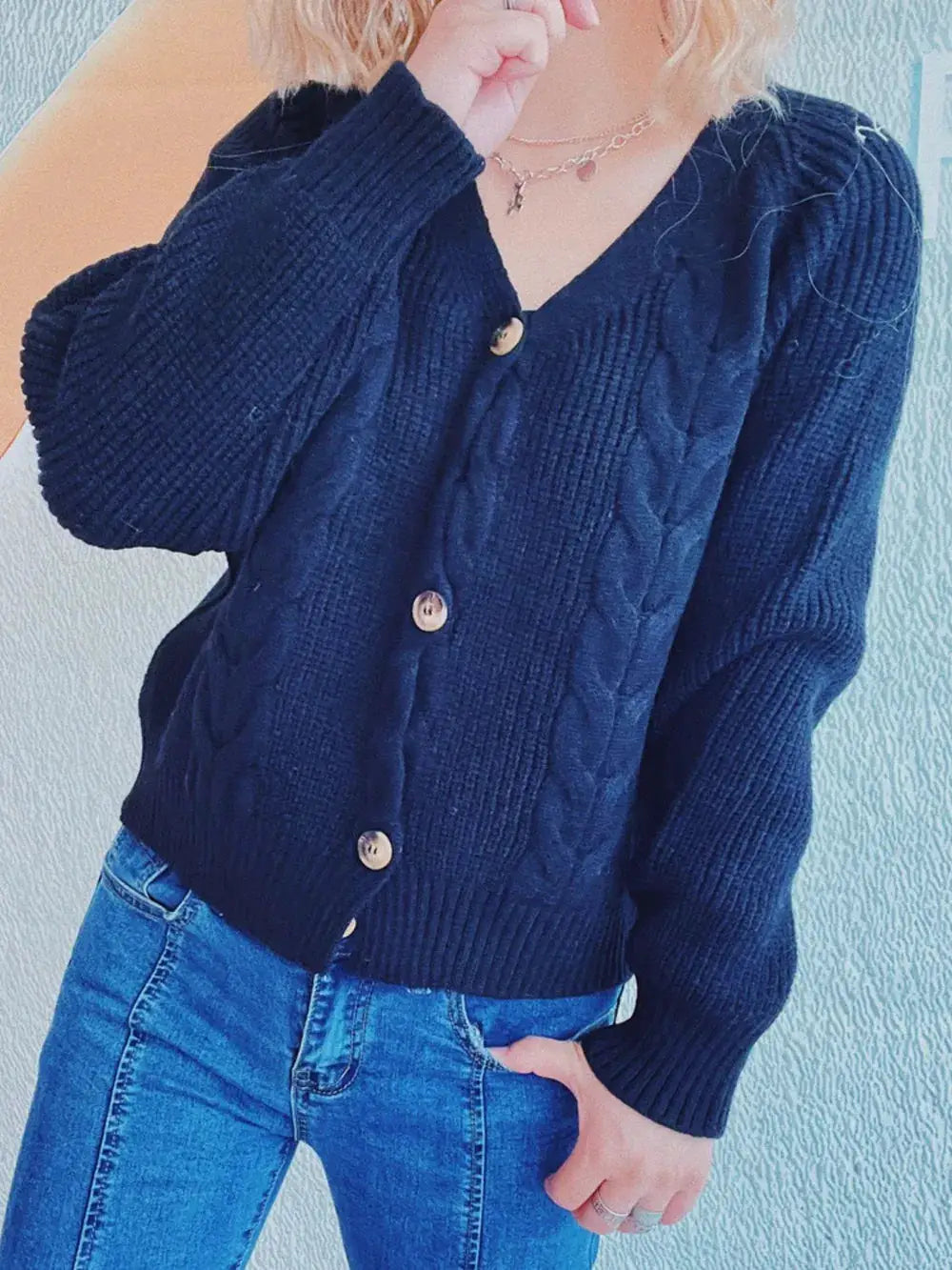 Soft cable knit V-neck cardigan with button front in navy blue.