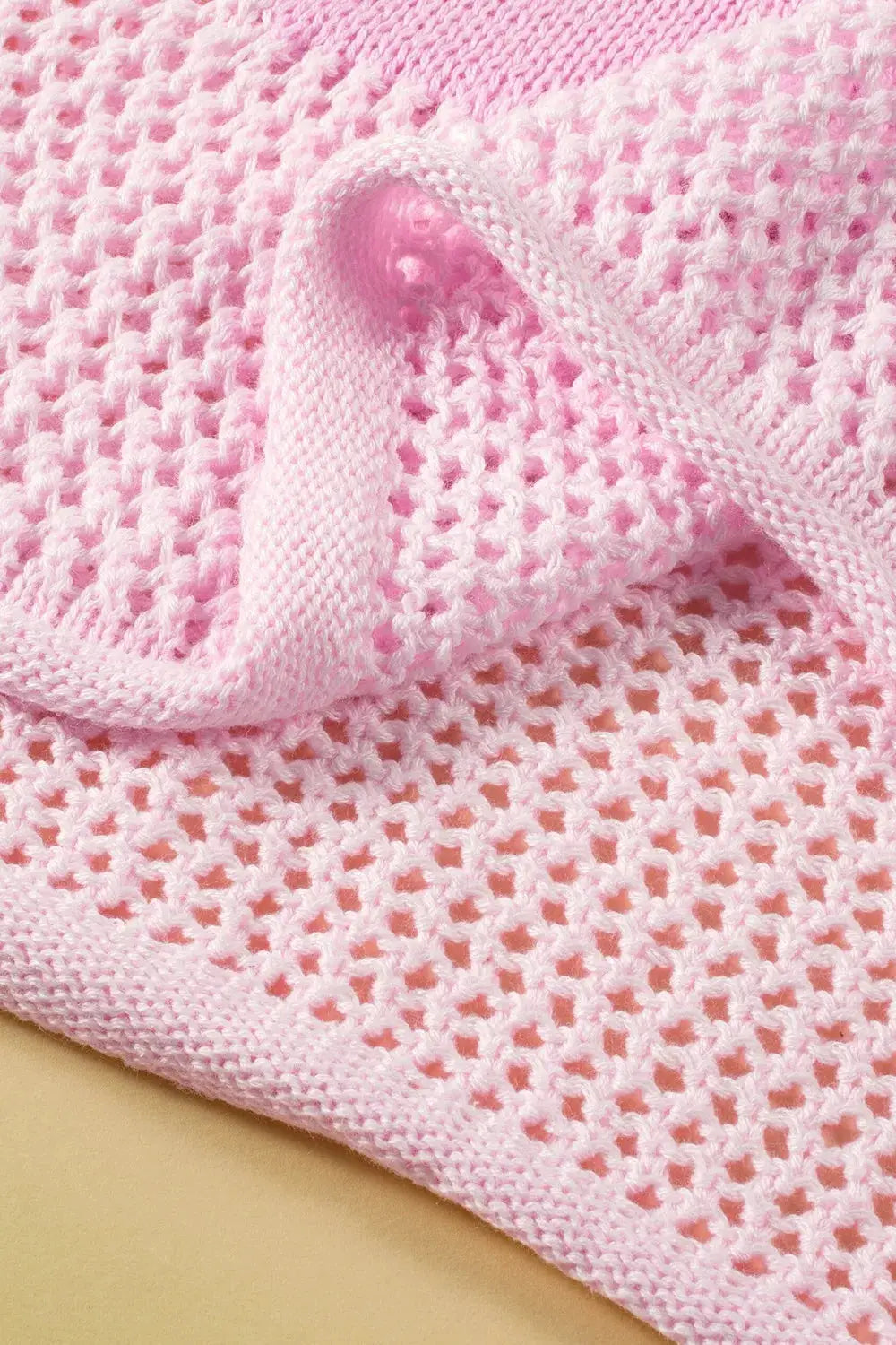 Lightweight pink openwork floral knit cover-up top with round neck.