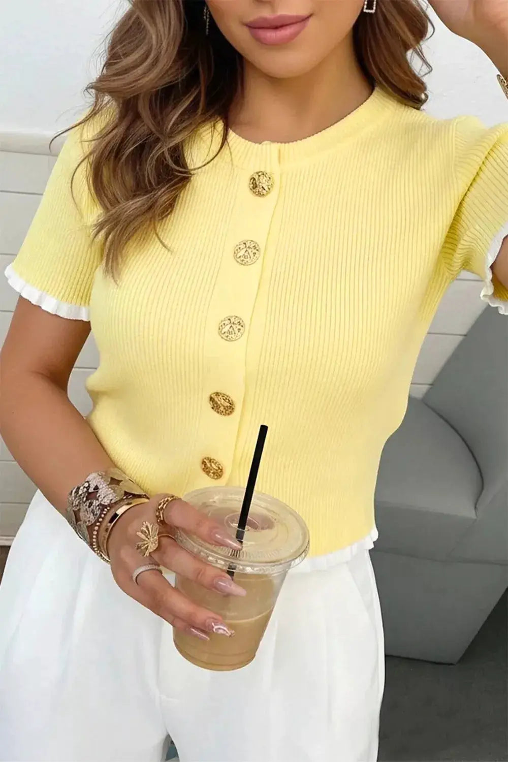 Yellow ribbed knit short-sleeve cardigan with white frill trim and gold buttons.