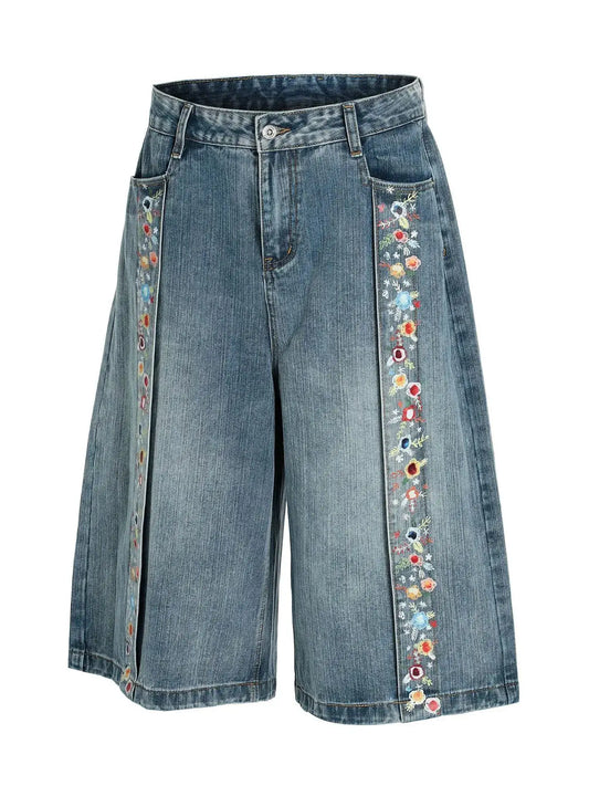 Men's denim shorts with wide-leg silhouette and floral-embroidered trim along the side seams