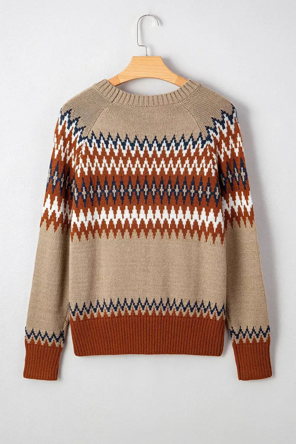 Geometric pattern long sleeve sweater in beige with rust, navy, and white zigzag stripes; ribbed hem and cuffs.