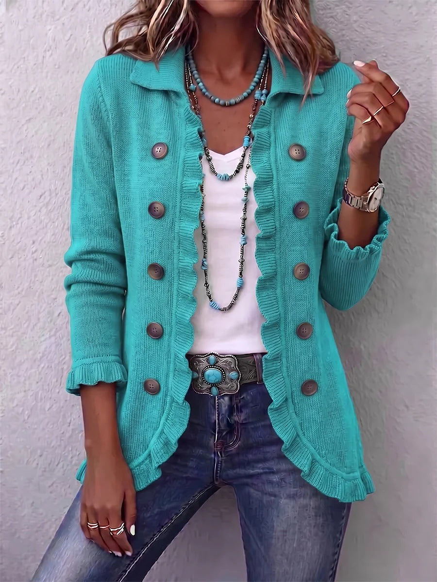 Long turquoise cardigan with ruffled edges and double-breasted buttons worn over a white top
