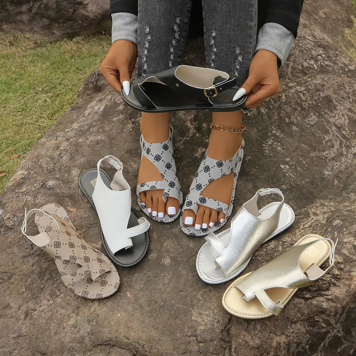 Toe Loop Flats Sandals by Trendsi; six pairs in black, white, metallics, and patterned beige displayed on a rock