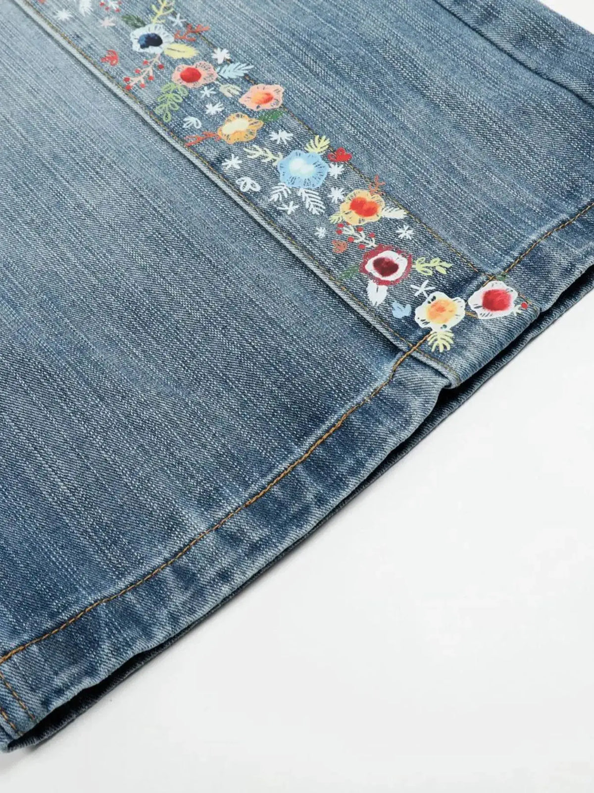 Men's floral-trim wide-leg denim shorts with embroidered floral detailing along the seam in blue denim