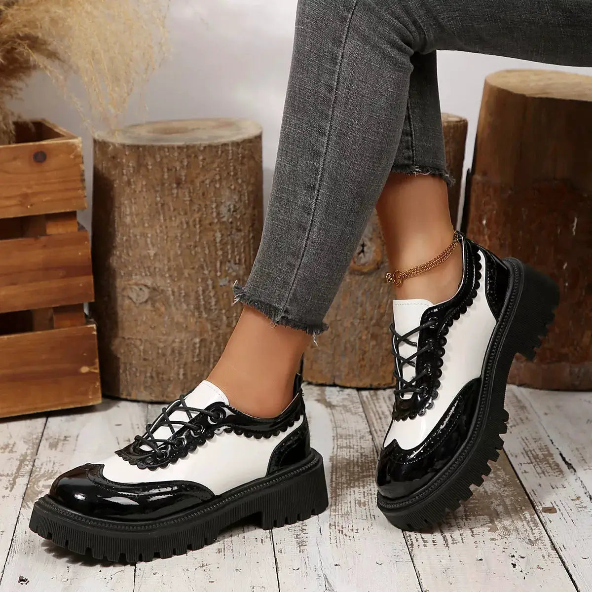 Pair of Round Toe Lace Up Sneakers in black patent and white panels with a chunky lug sole