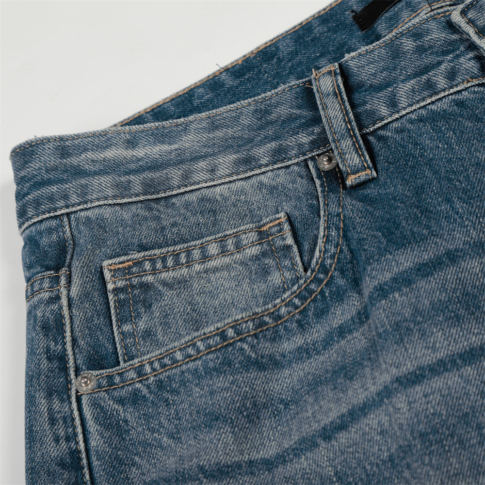 Denim jeans close-up showing front pocket and belt loop in blue washed denim