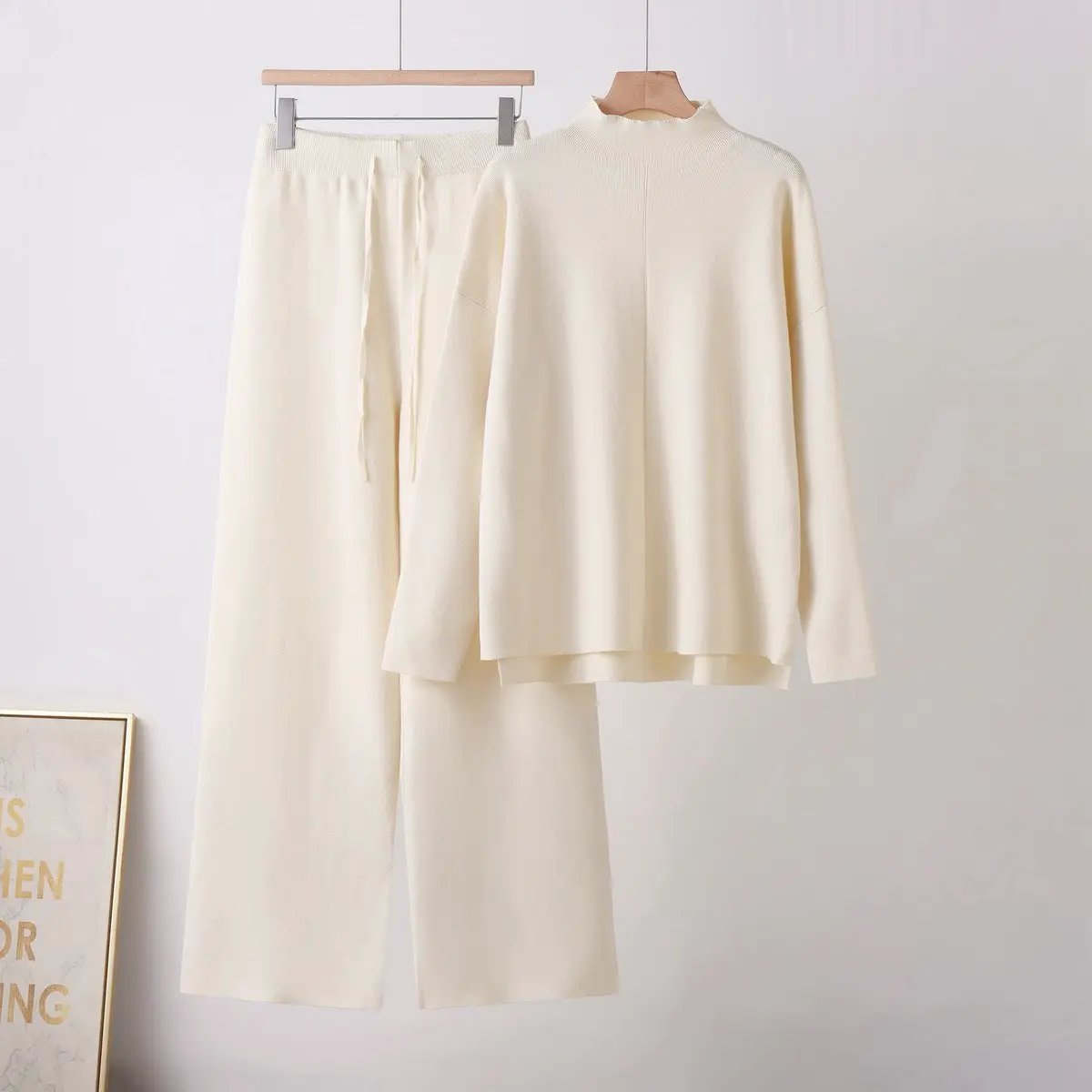 Soft knit two-piece set by eprolo with stand-up collar top and matching wide-leg pants in cream