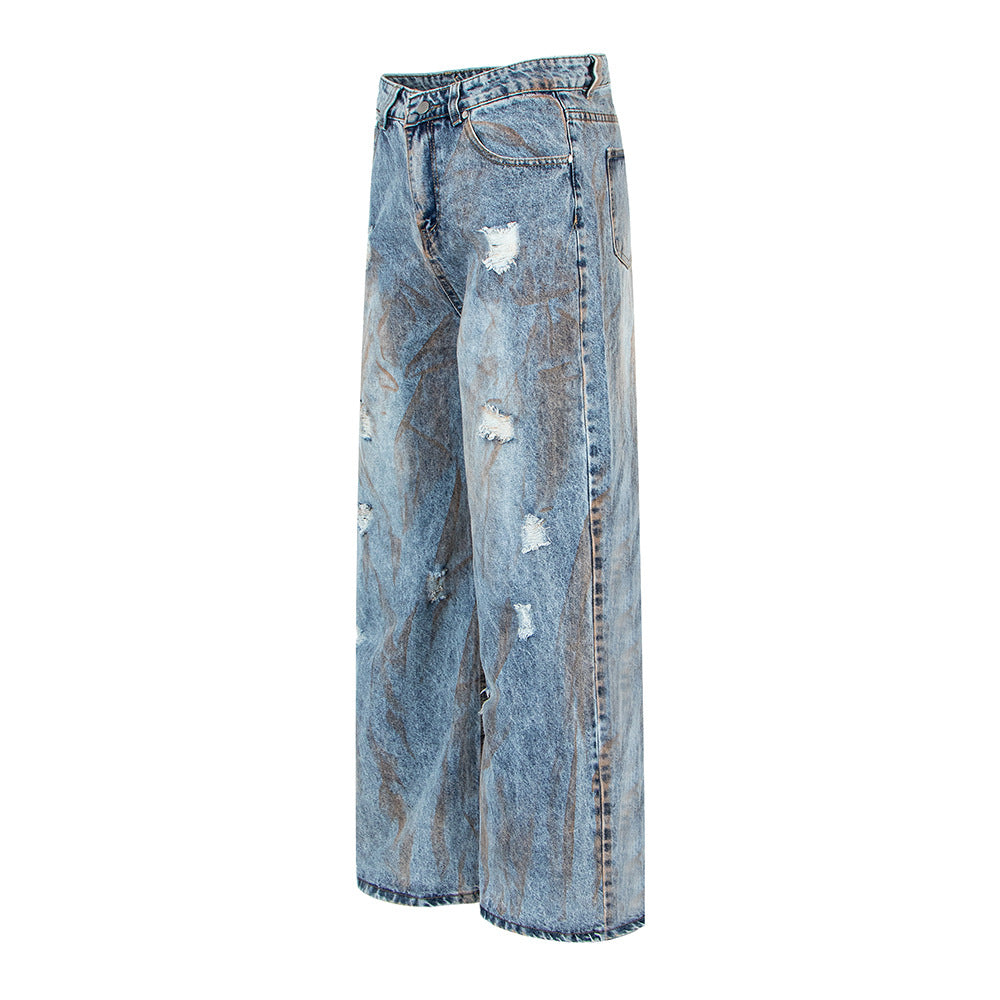 Washed blue denim jeans with distressed patches, oversized straight leg cut