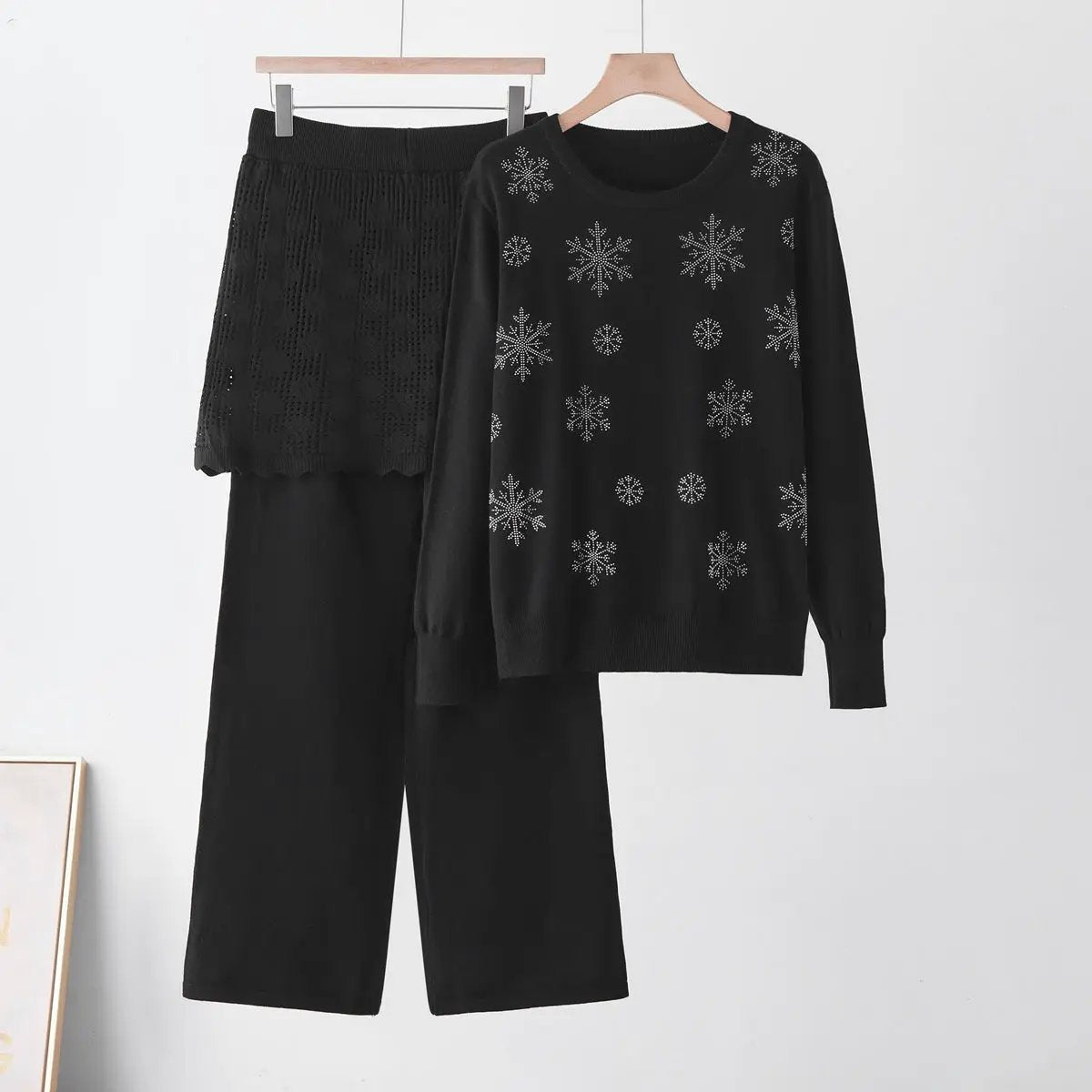 Two-piece black knit set: round-neck rhinestone snowflake sweater and matching pants.