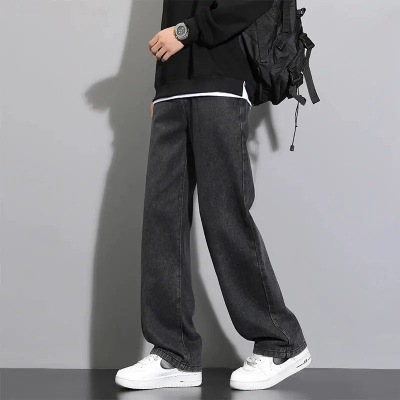 Premium blue denim jeans with a relaxed baggy fit worn with white sneakers on a model