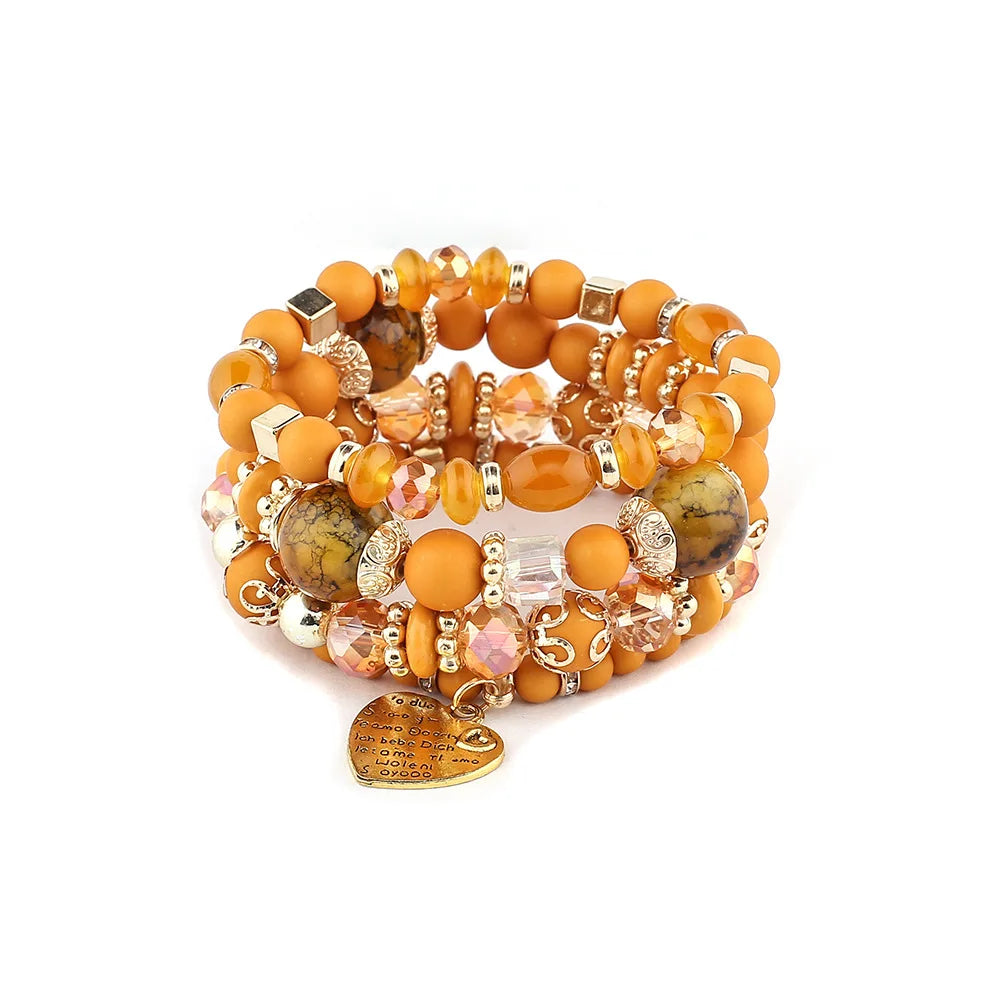 Boho crystal heart bracelet set, stackable elastic jewelry with orange beads, gold-tone spacers, and a heart charm.