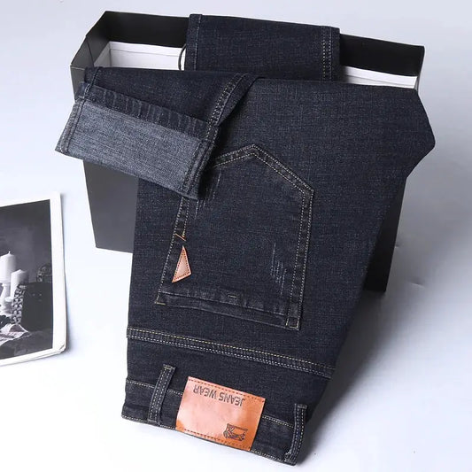 Premium dark-wash slim-straight stretch denim jeans with back pocket orange patch, folded in box.