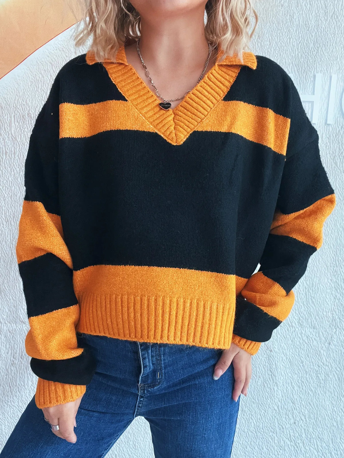 Color-block long-sleeve sweater in black with orange stripes; ribbed cuffs and hem, soft stretch polyester blend