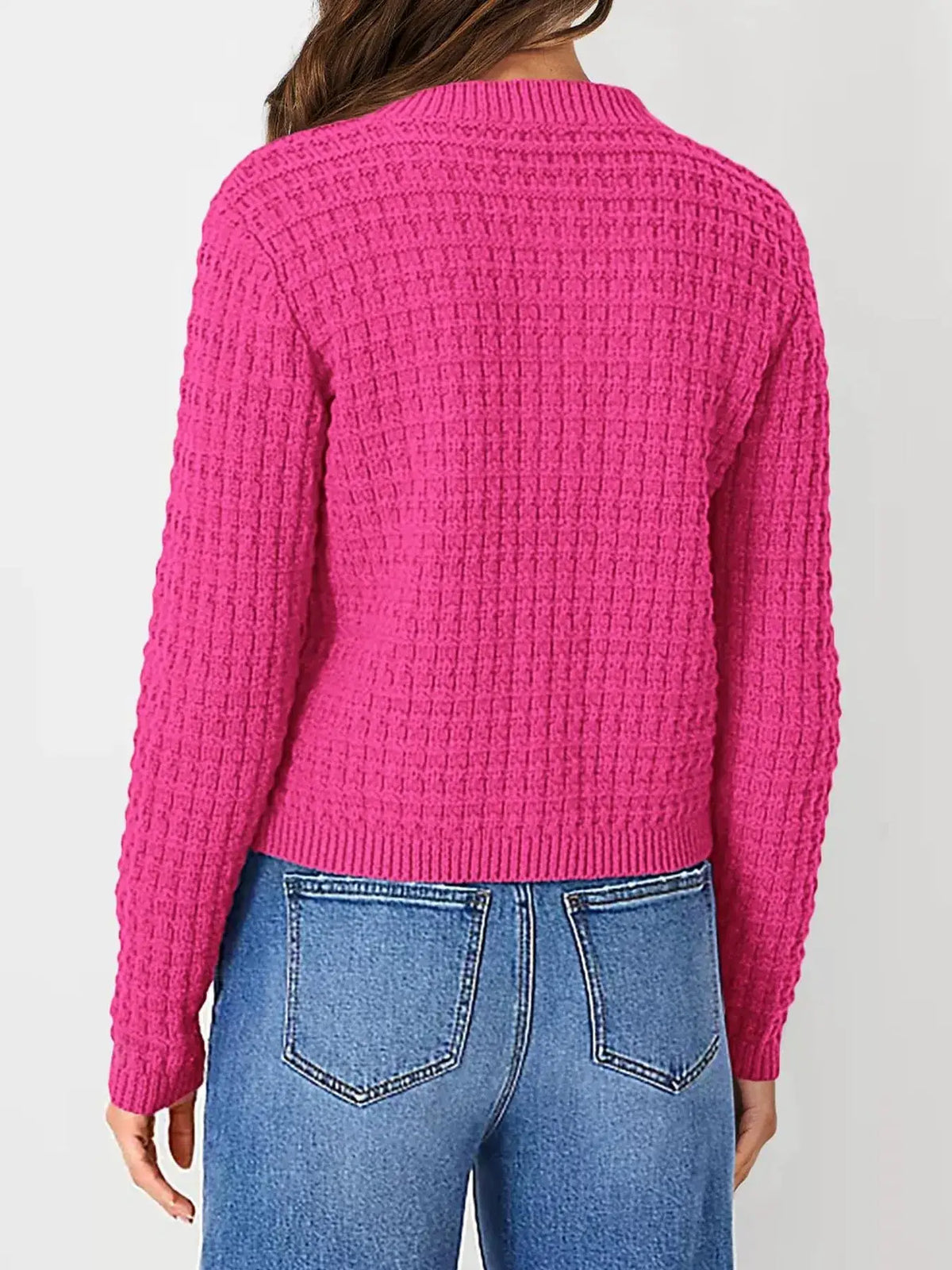 Textured stretchy knit cardigan in bright pink, back view with ribbed hem and cuffs, paired with jeans