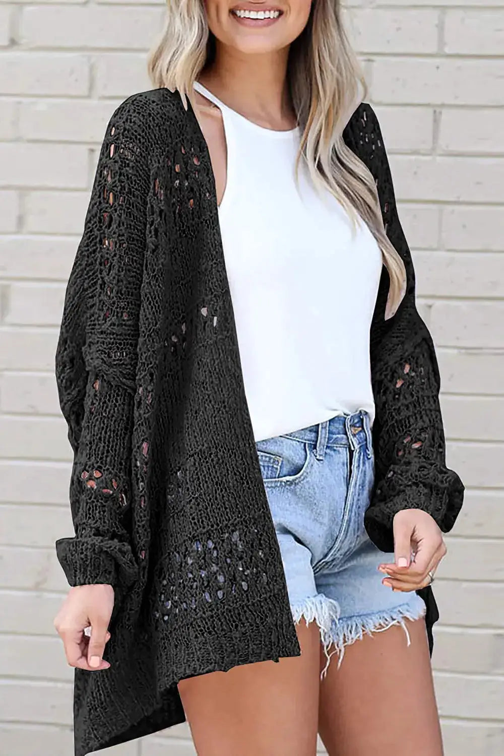 Openwork acrylic cardigan in black with an open front and long sleeves.