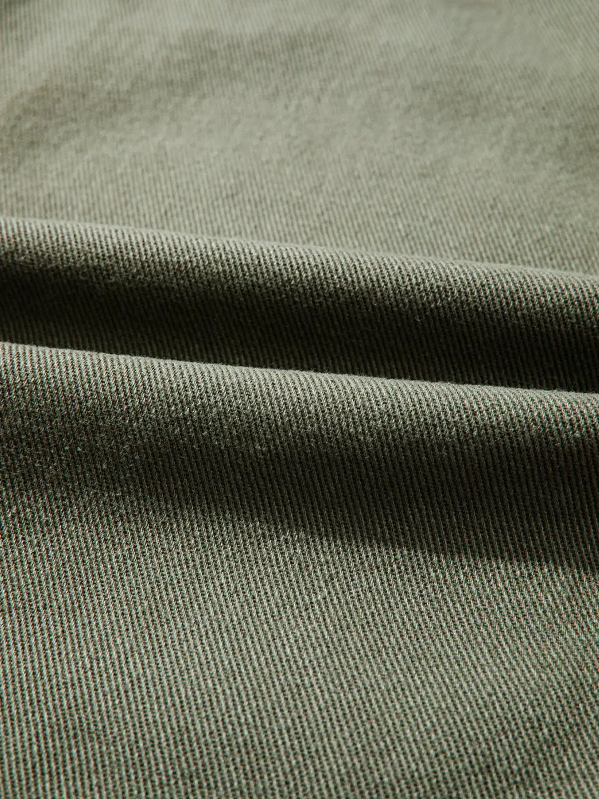 Denim jacket fabric close-up in gray-blue with twill weave.